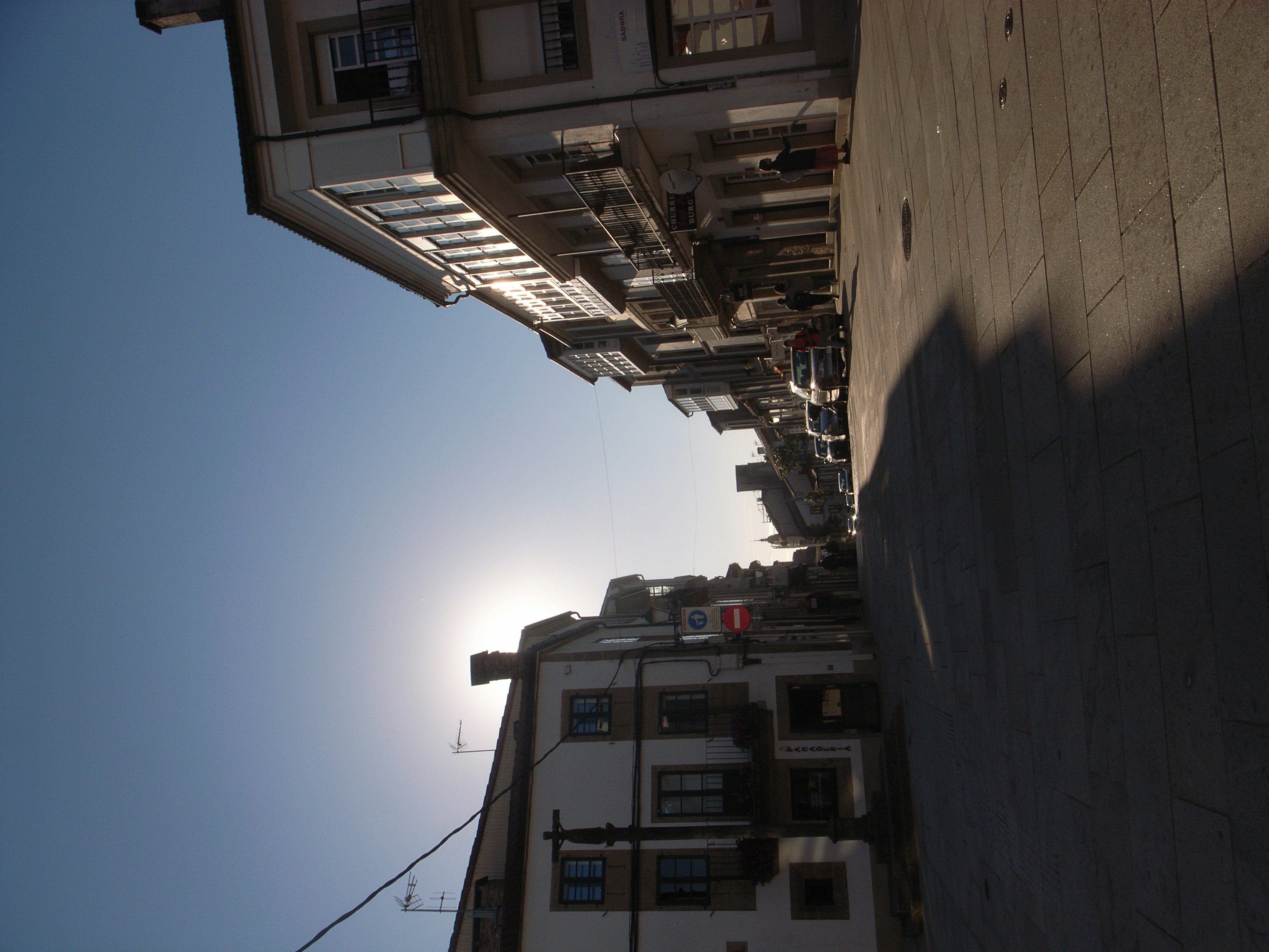 Quiet street with buildings silhouetted against a clear sky