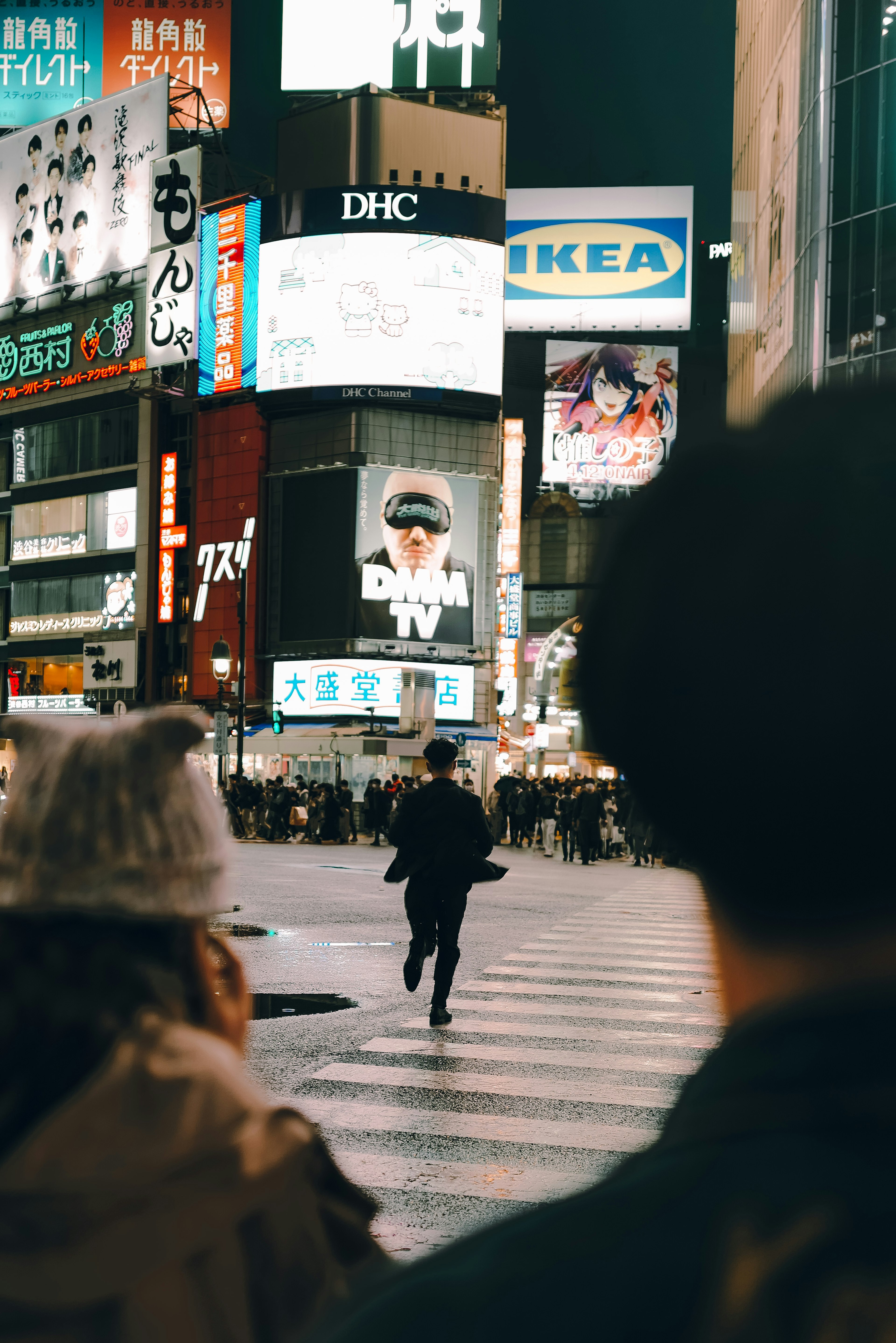 Une personne courant dans une rue animée avec des publicités illuminées