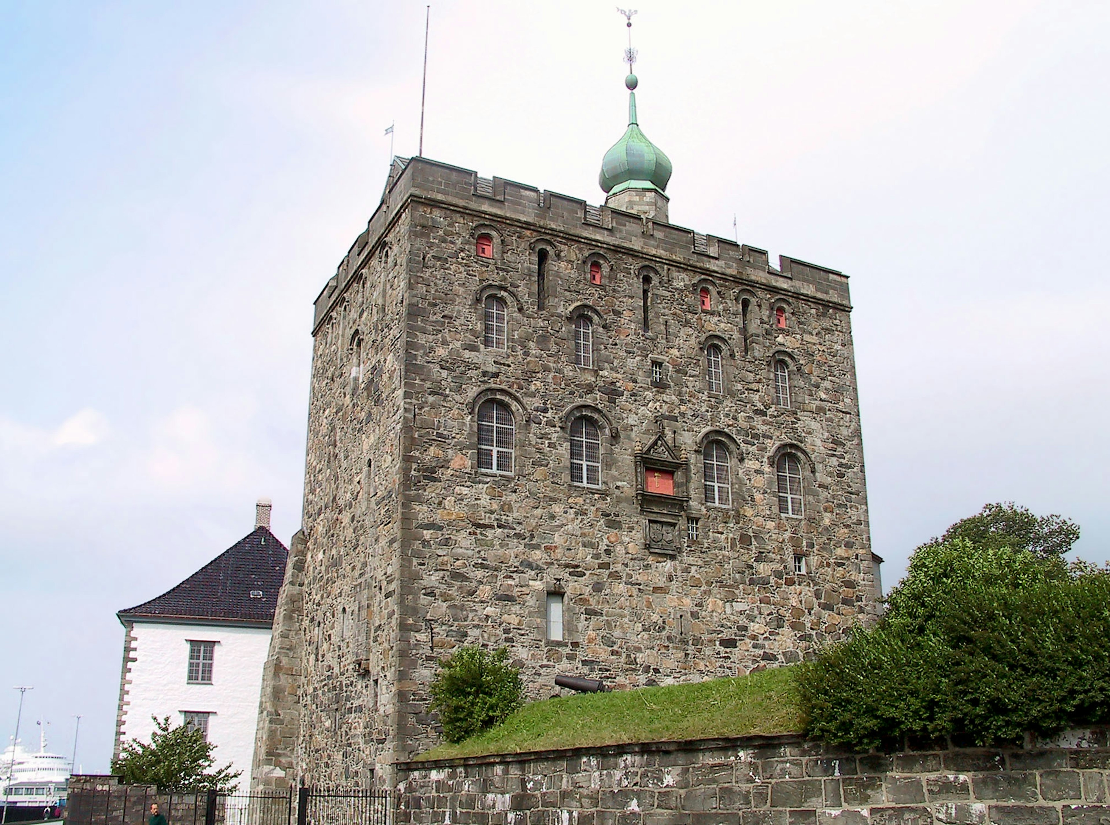 Stone tower building with a green dome and red accents