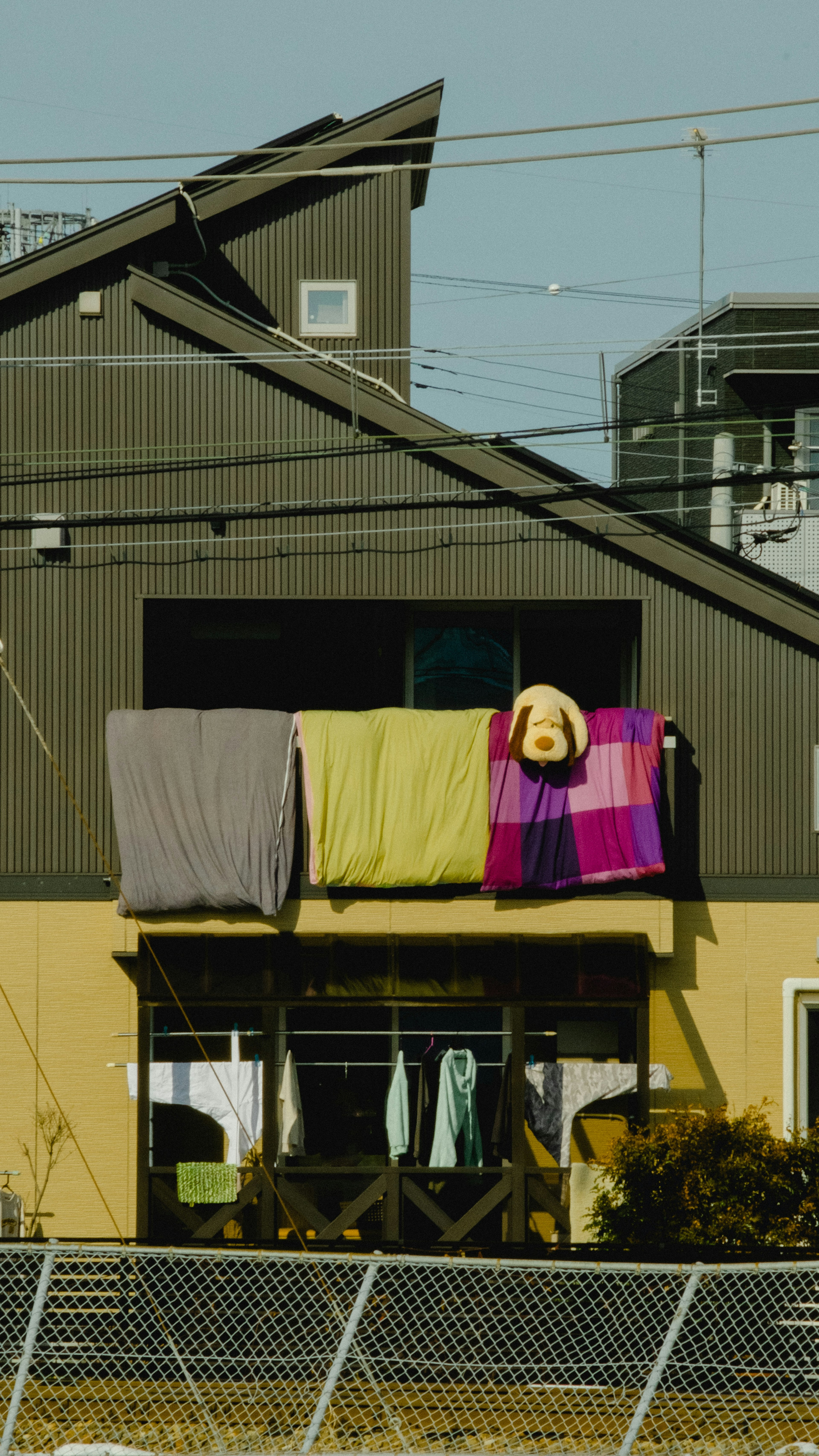 Colorful blankets and towels hanging on a house balcony