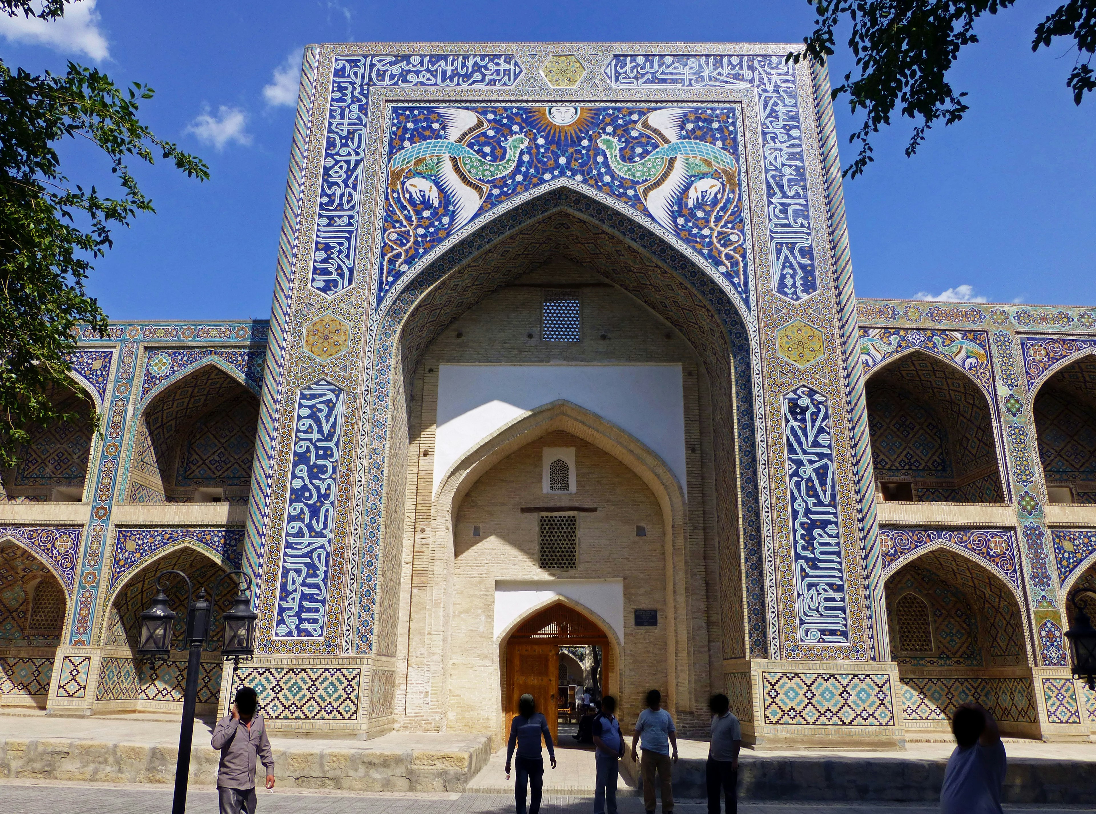 Grande entrée avec arche carrelée bleue et bâtiment historique