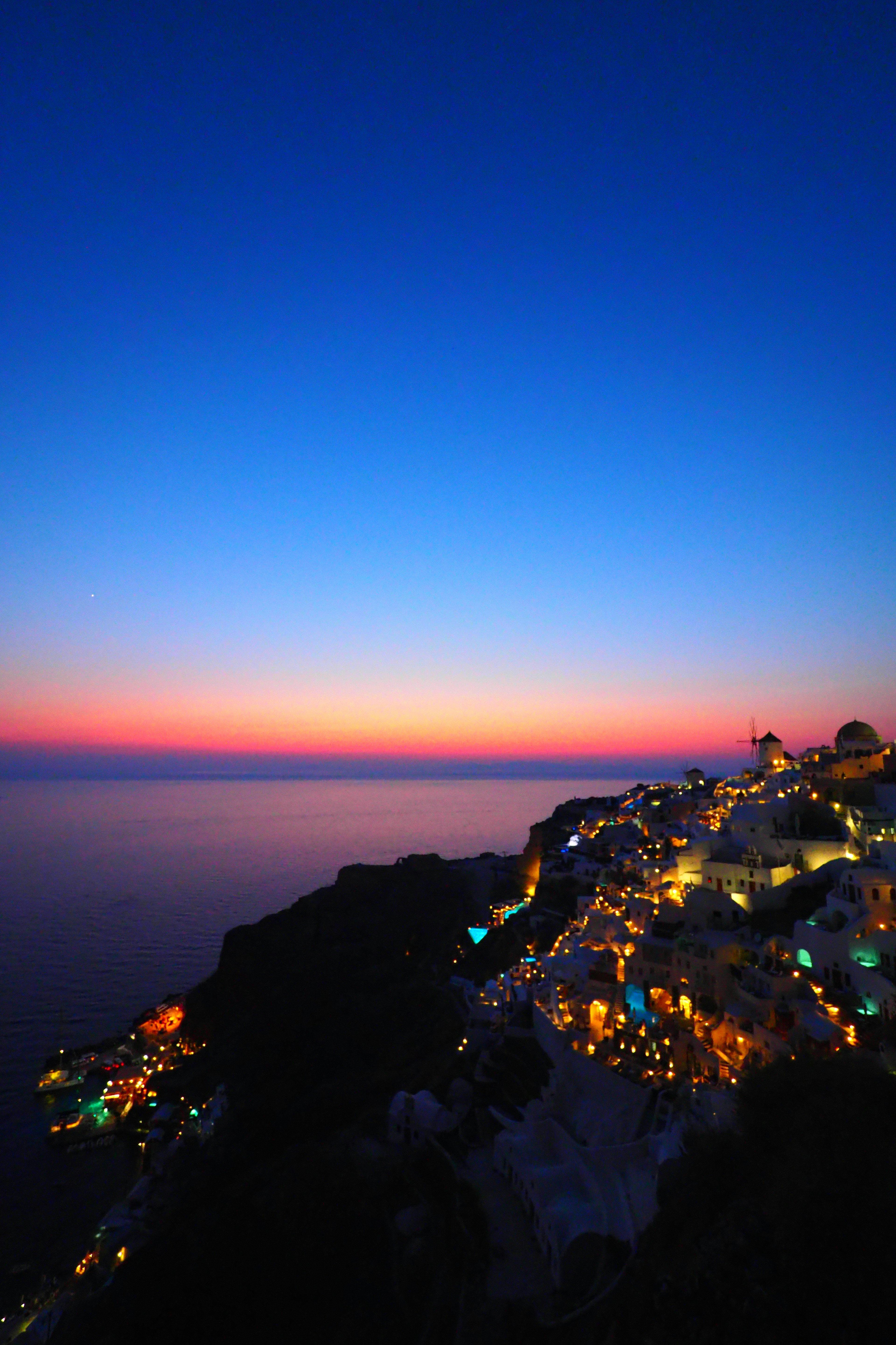 Hermosa costa al atardecer con casas iluminadas