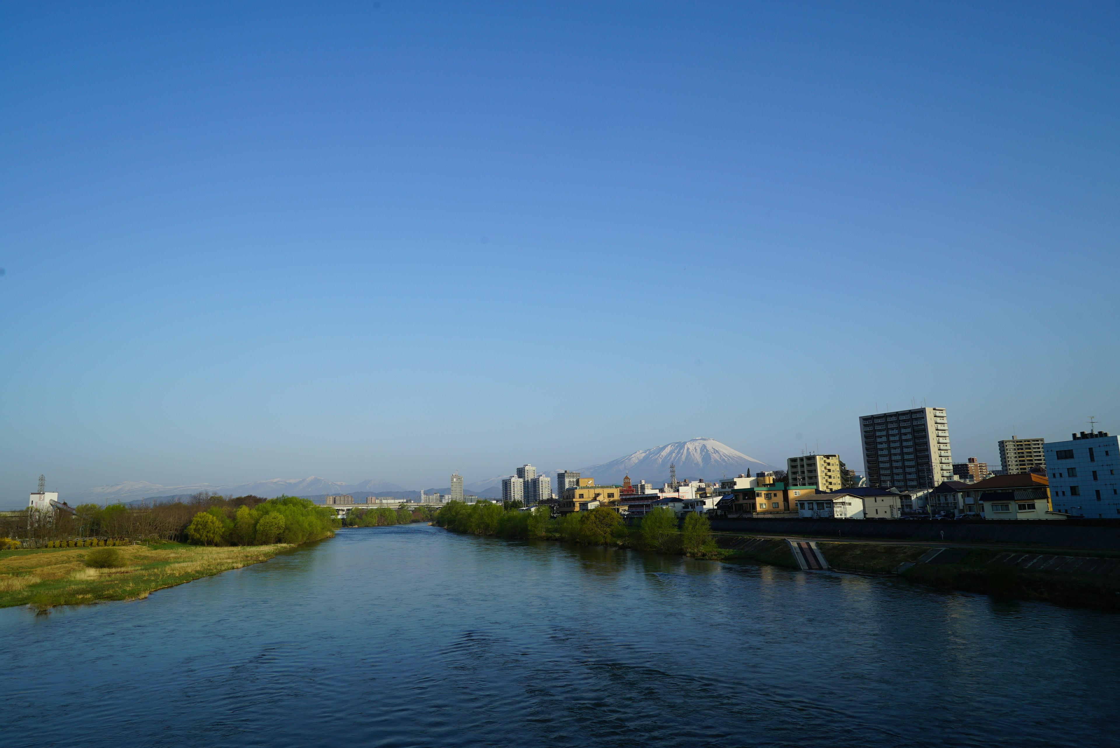 Paysage de rivière avec ciel bleu clair et montagne enneigée en arrière-plan