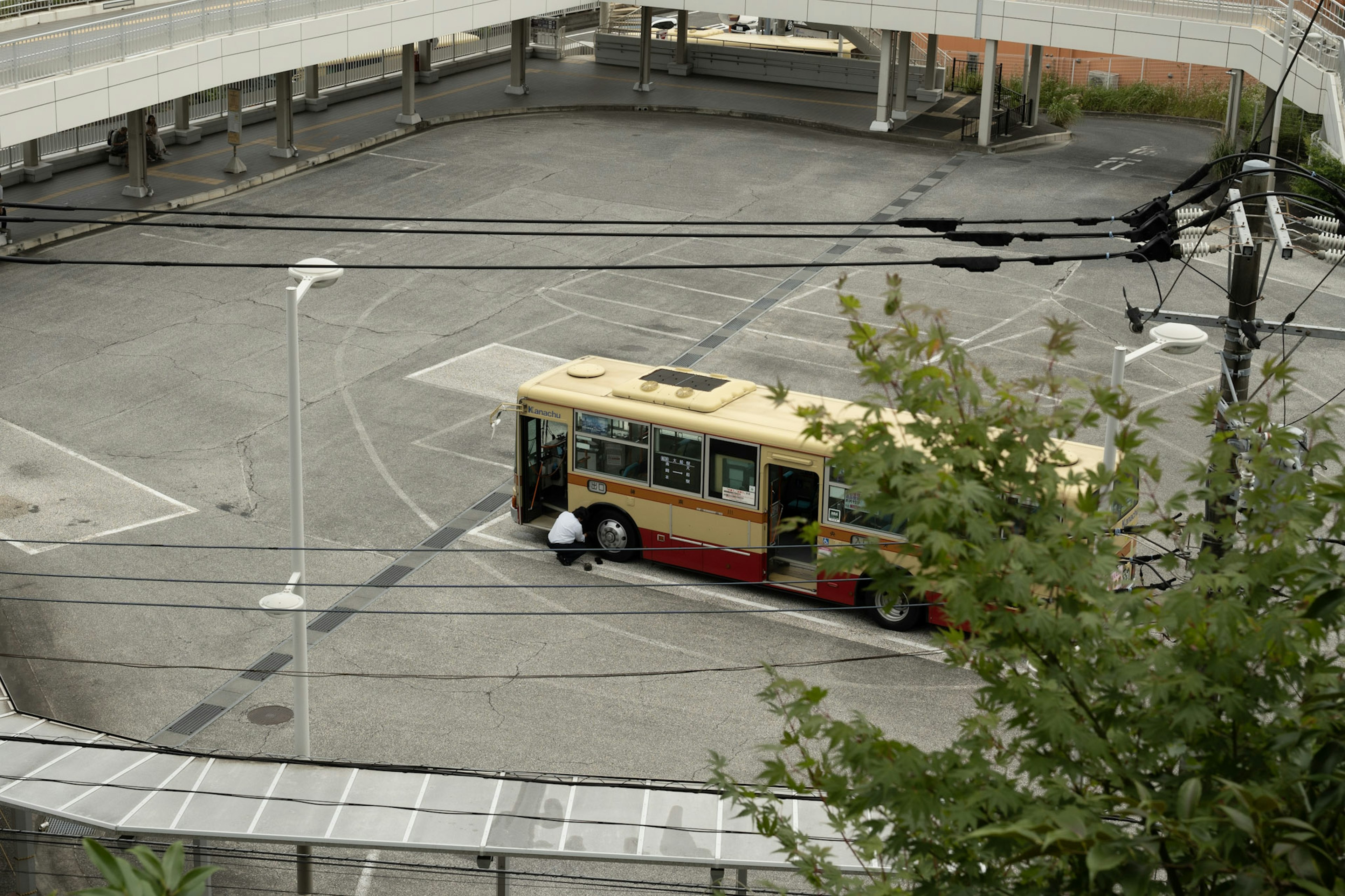 A bus parked in an empty lot with surrounding infrastructure