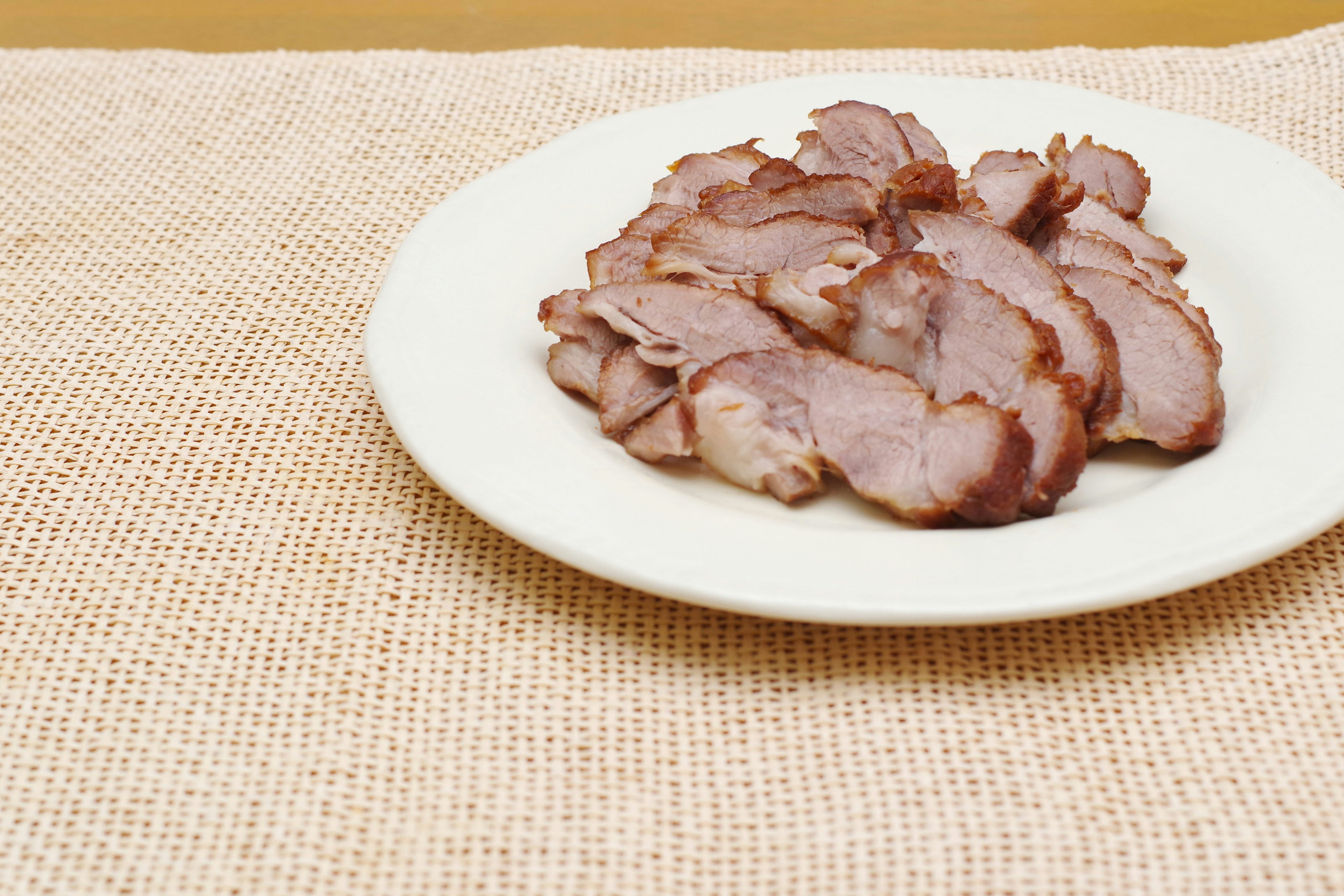 Thinly sliced meat arranged on a white plate