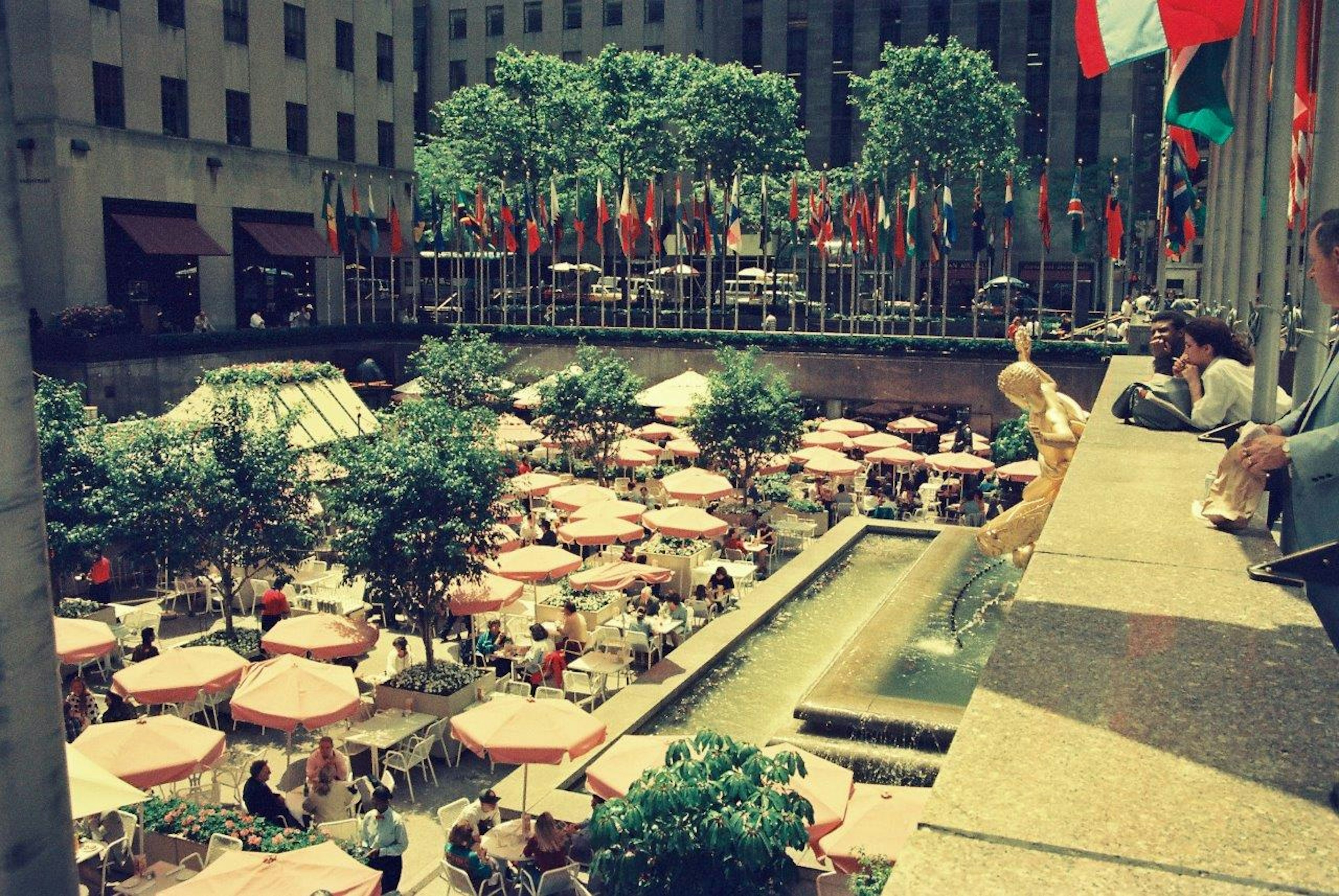 Outdoor café at Rockefeller Center featuring umbrellas and lush greenery