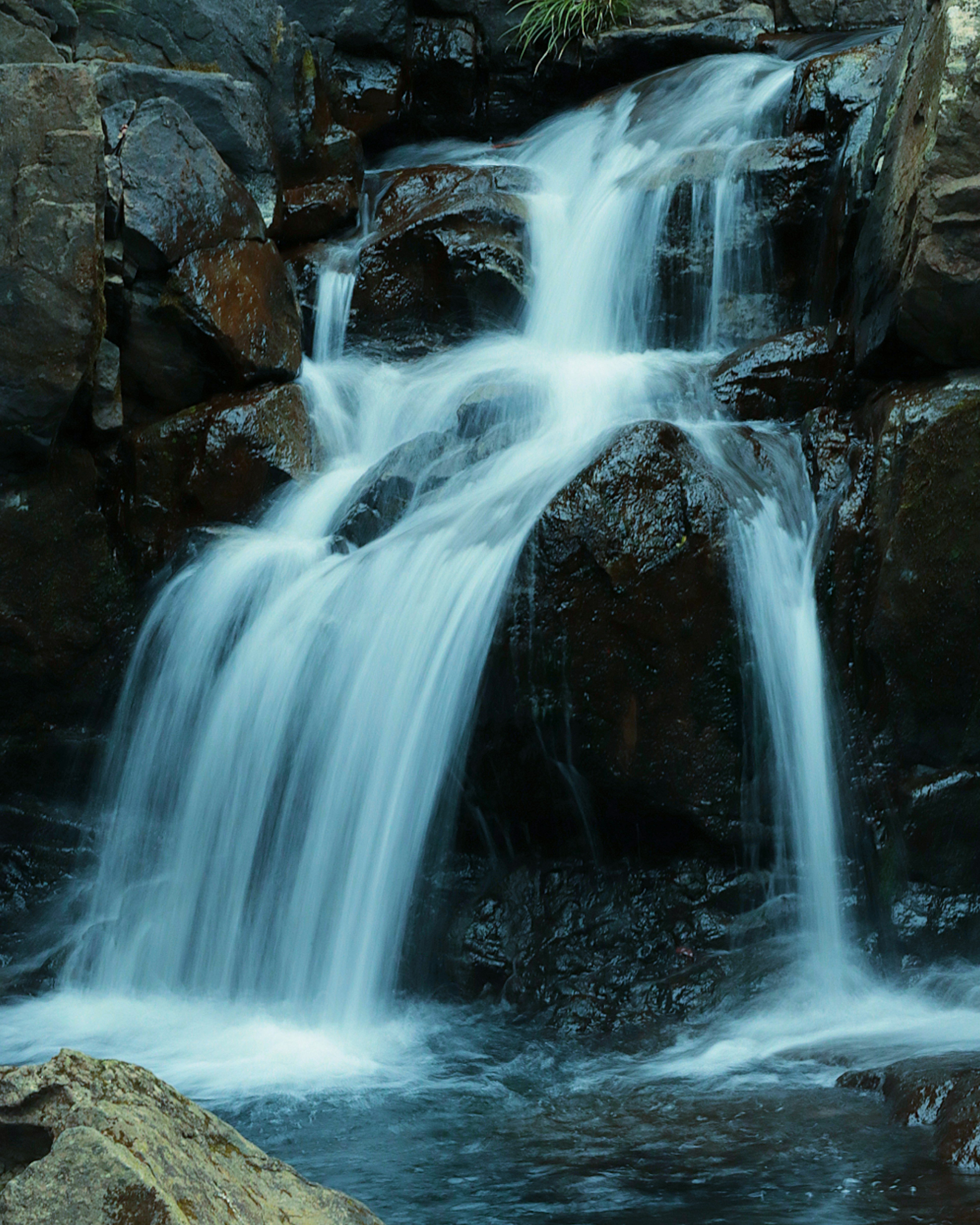 Air terjun yang indah mengalir di atas batu