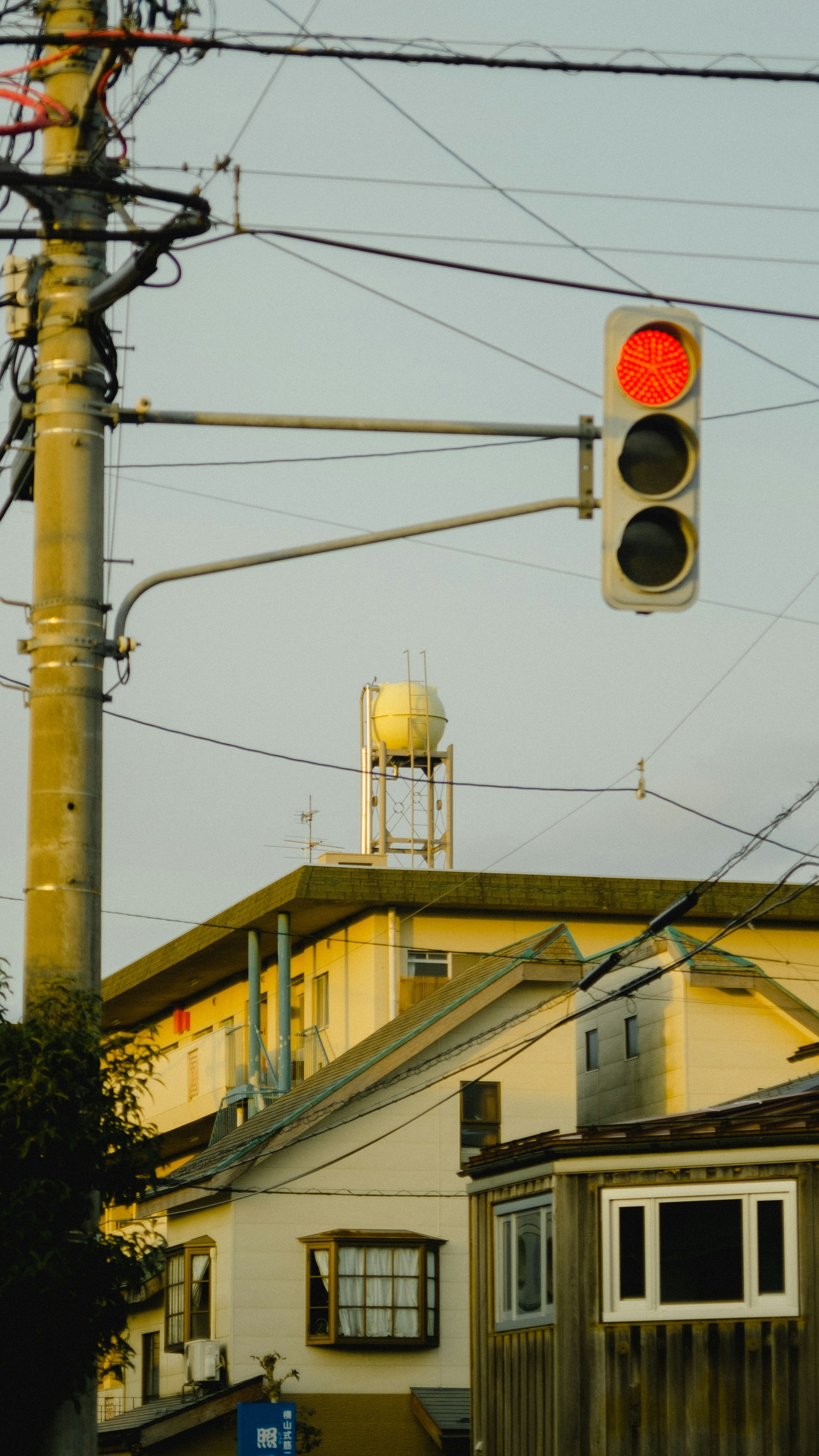 Vista de la calle con un semáforo rojo y un tanque de agua