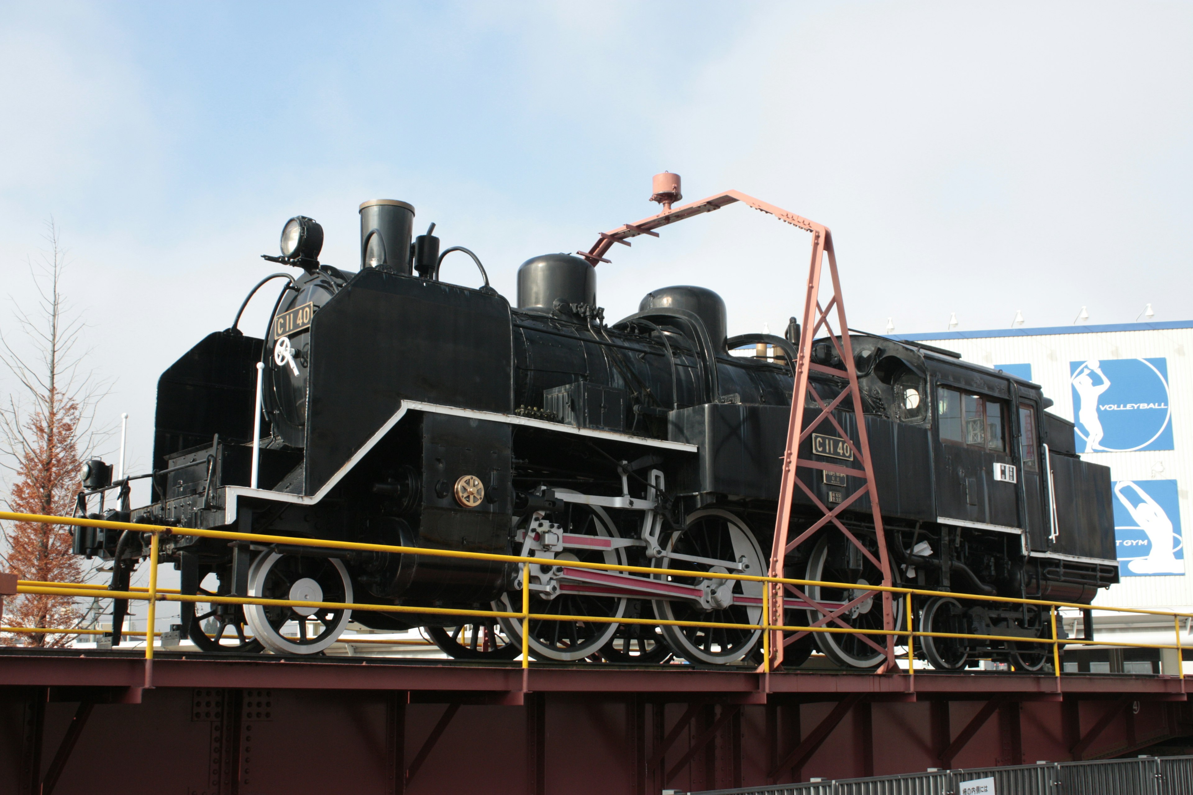 Locomotora de vapor negra exhibida en una plataforma al aire libre