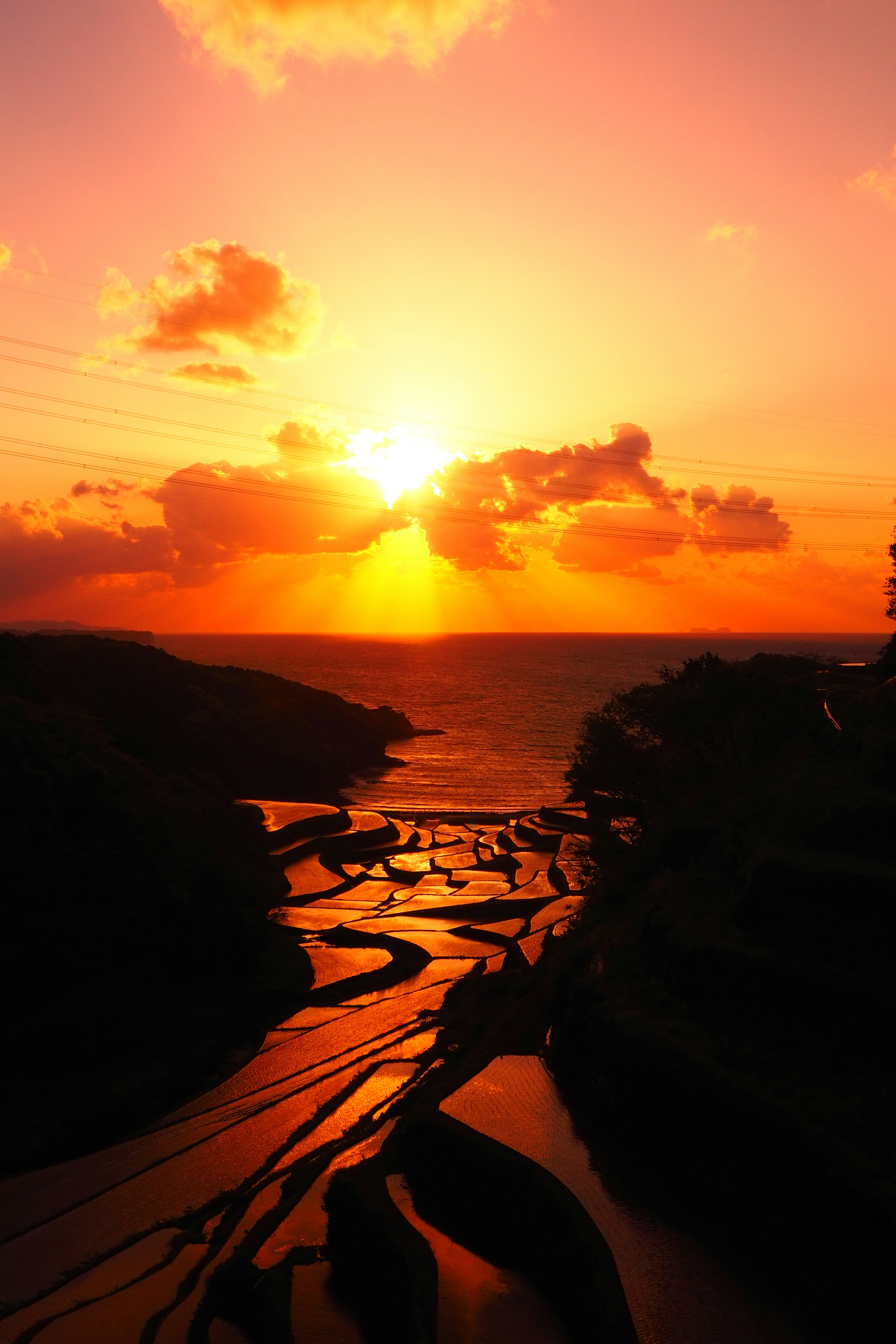 美しい夕日が海に沈む風景と黒い川の流れ