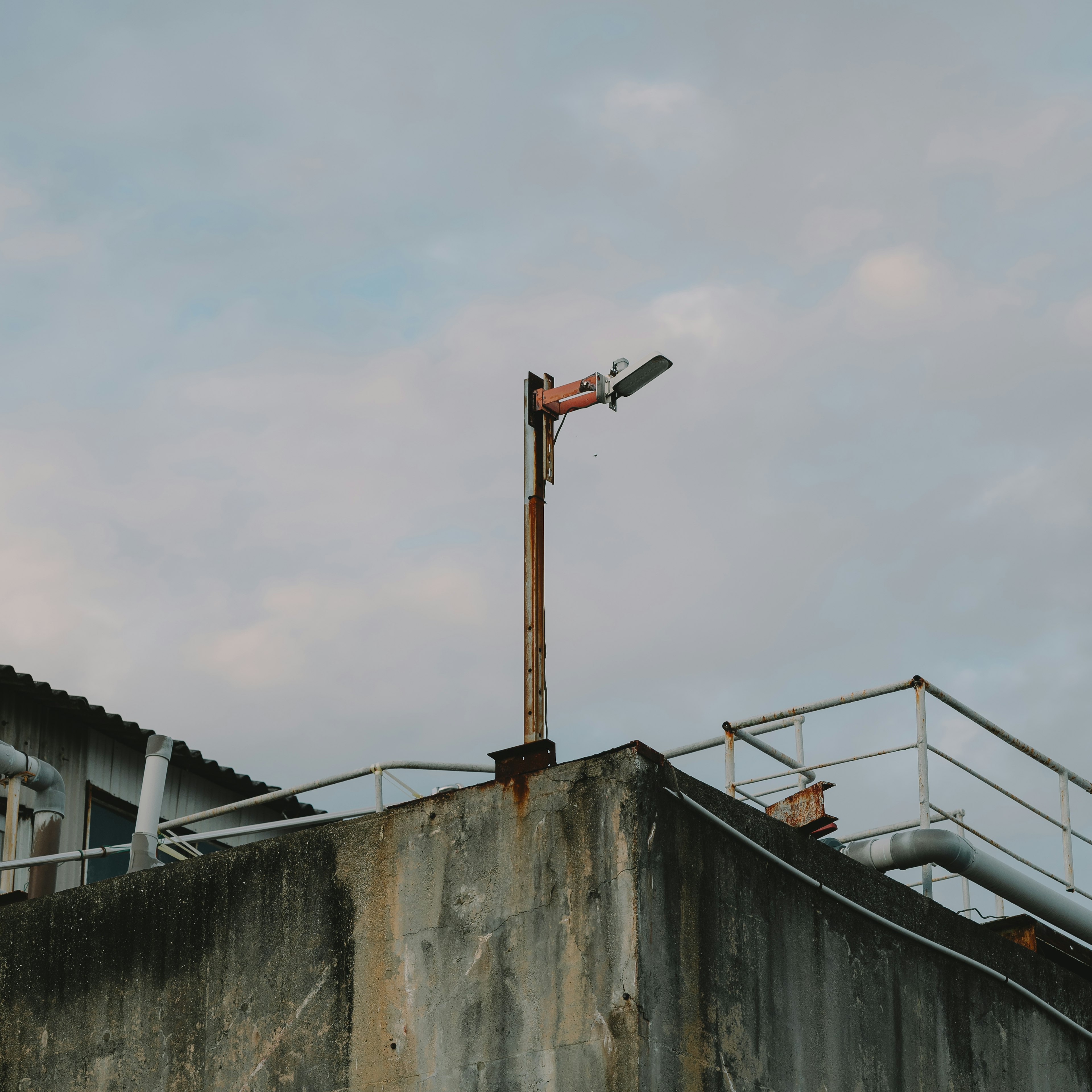 Streetlight on top of an old building with cloudy sky