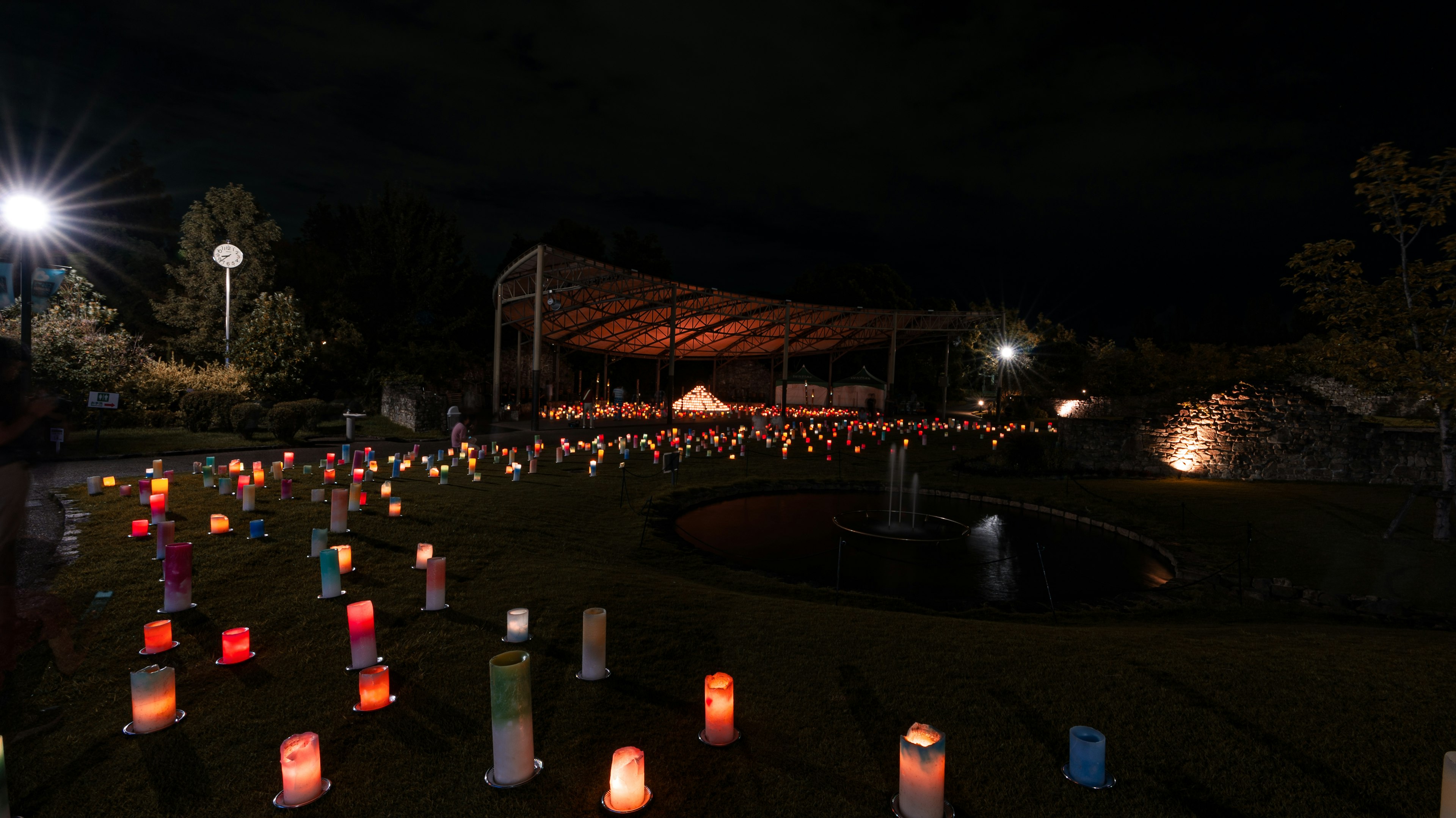 夜の公園で色とりどりのキャンドルが並ぶ光景