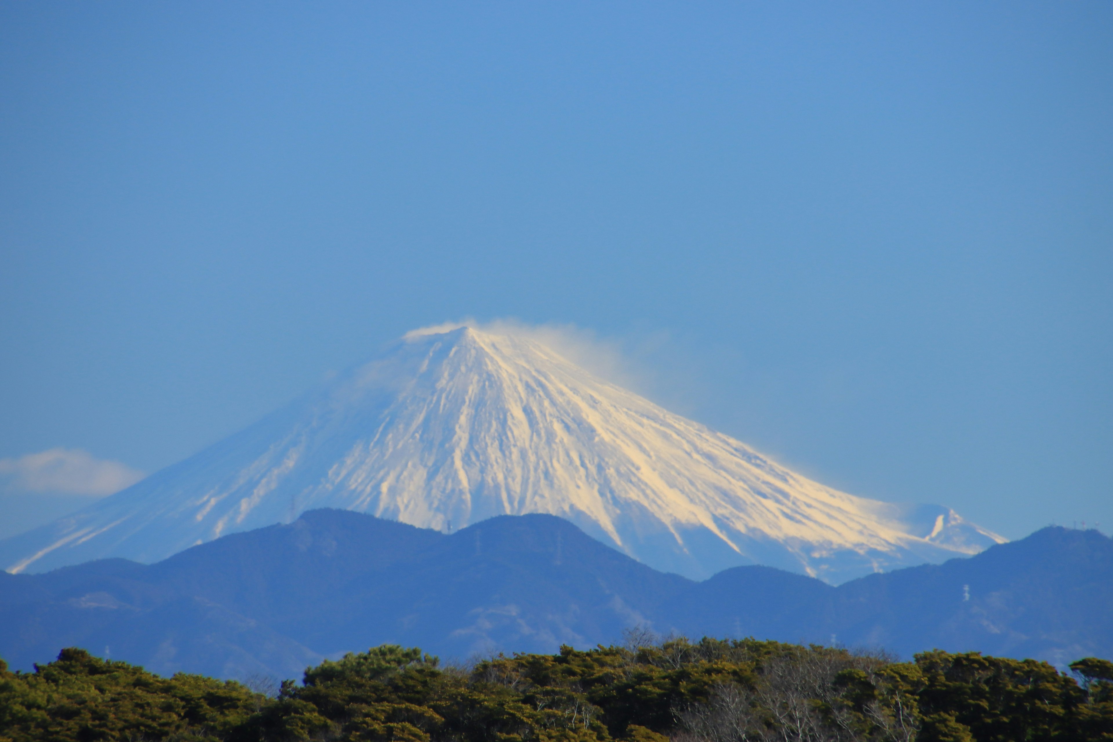 Cima de montaña cubierta de nieve contra un cielo azul claro