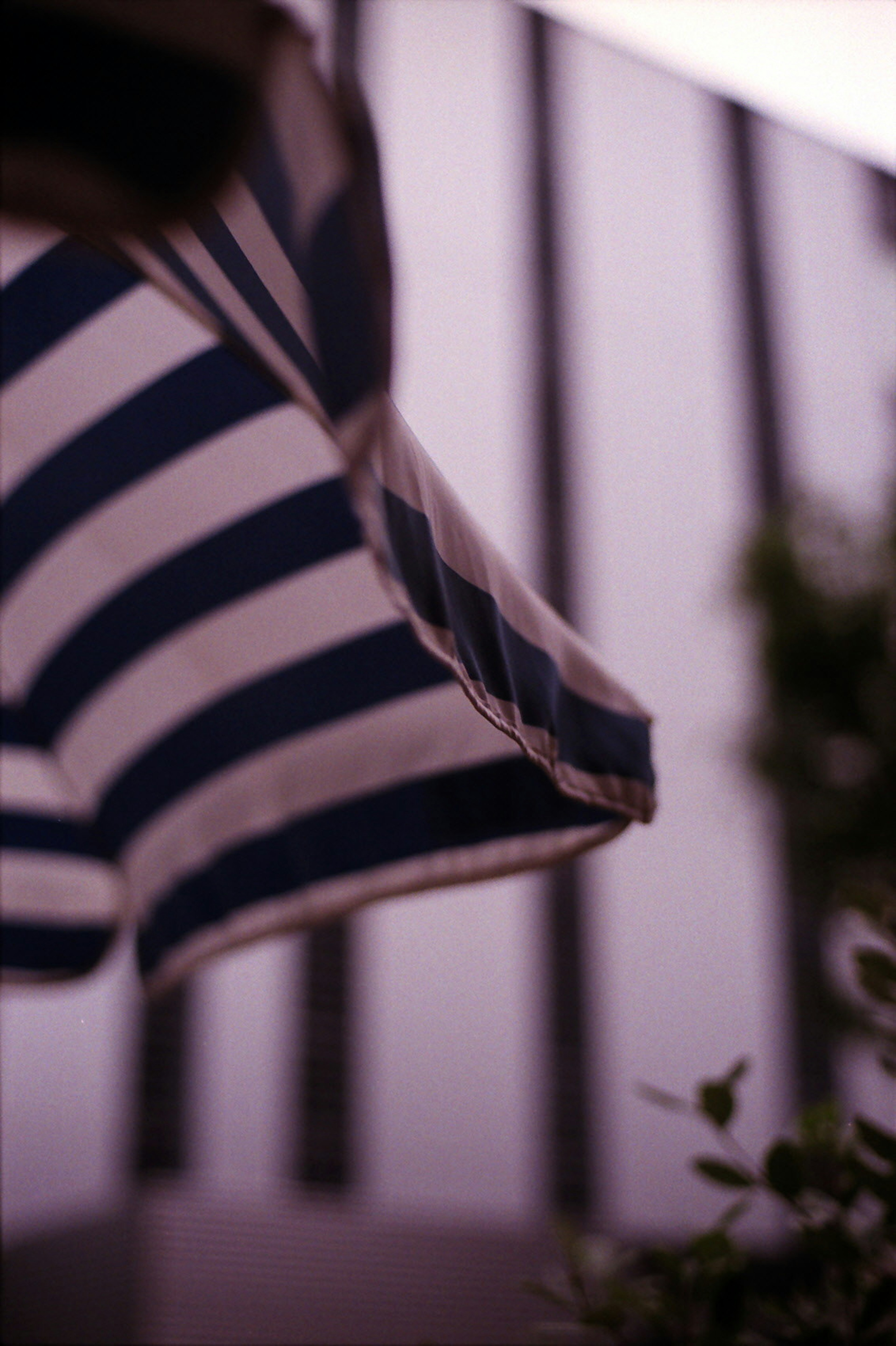 Image features a striped umbrella with a modern building in the background