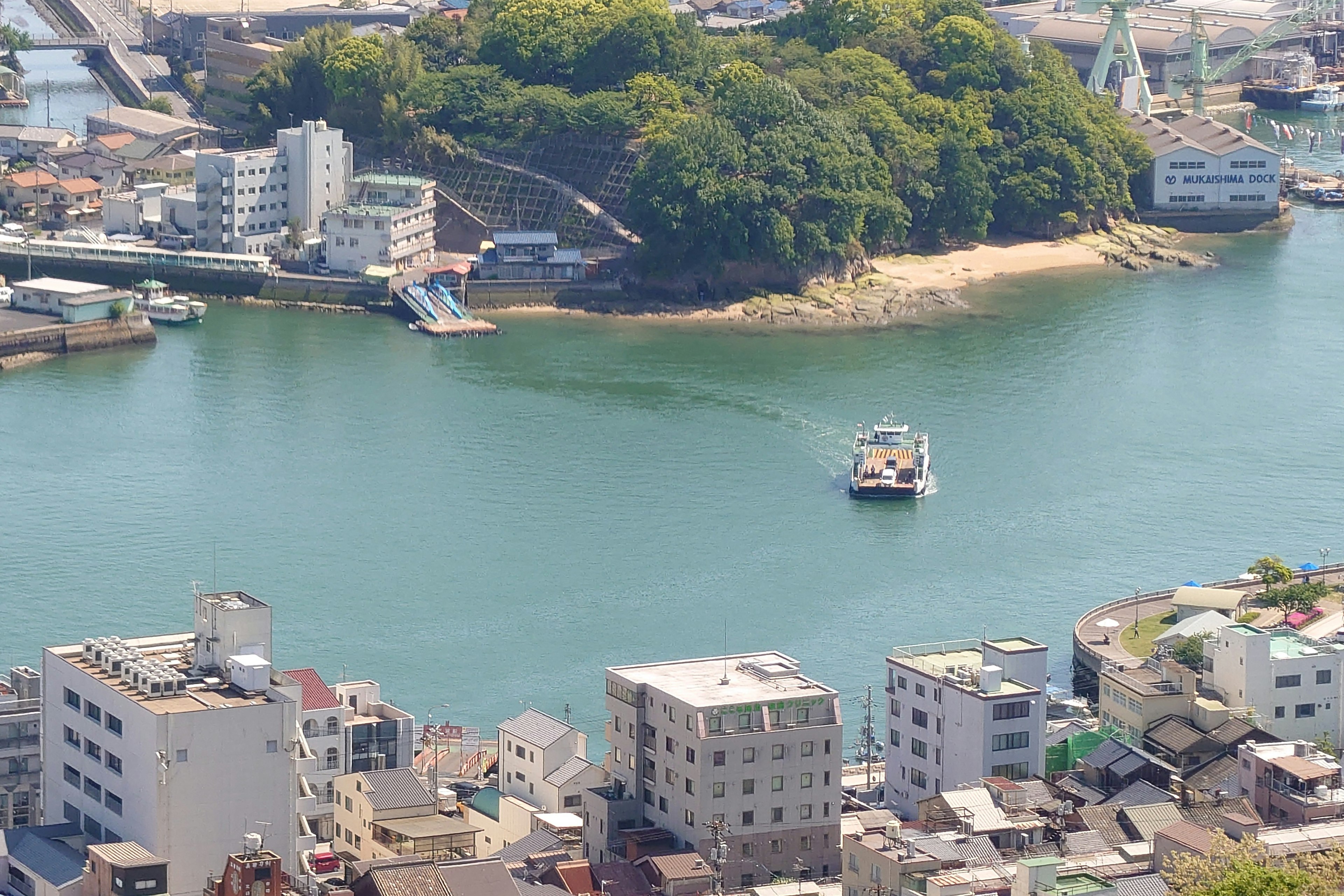 海に浮かぶ船と緑豊かな島が見える風景