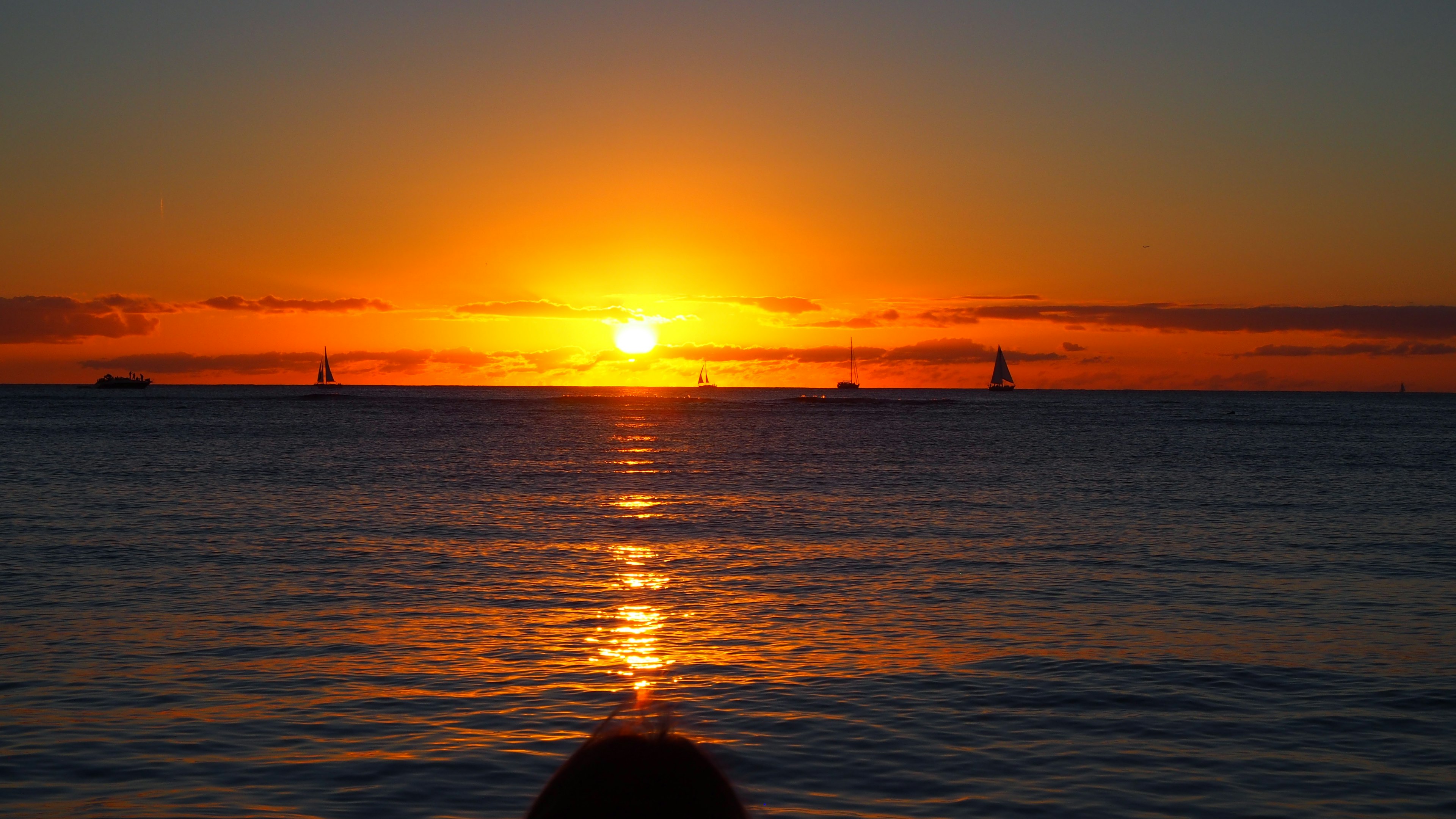 Silhouette of a person watching the sunset over the ocean