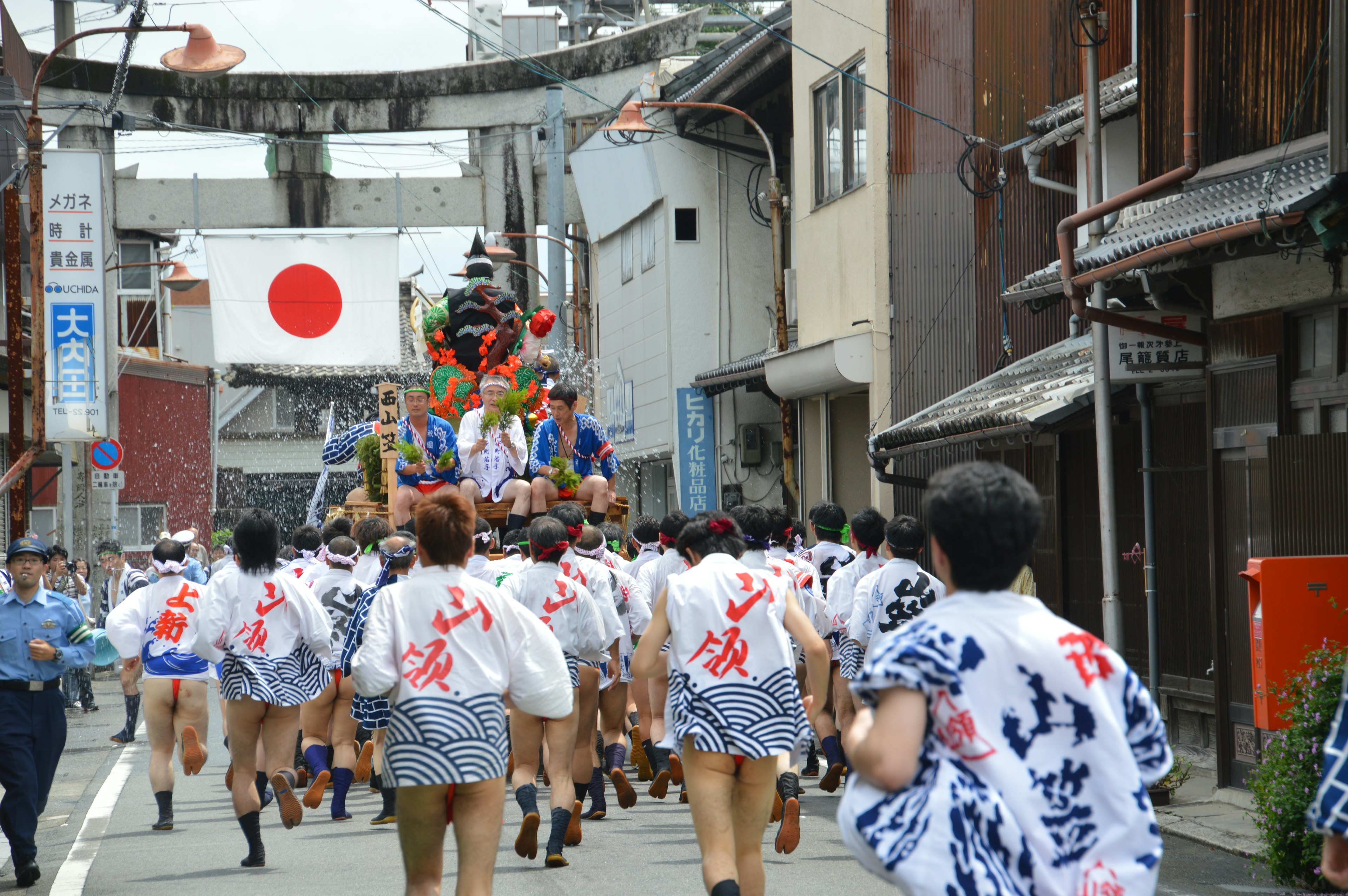 Participants en tenue traditionnelle tirant une charrette lors d'un festival japonais