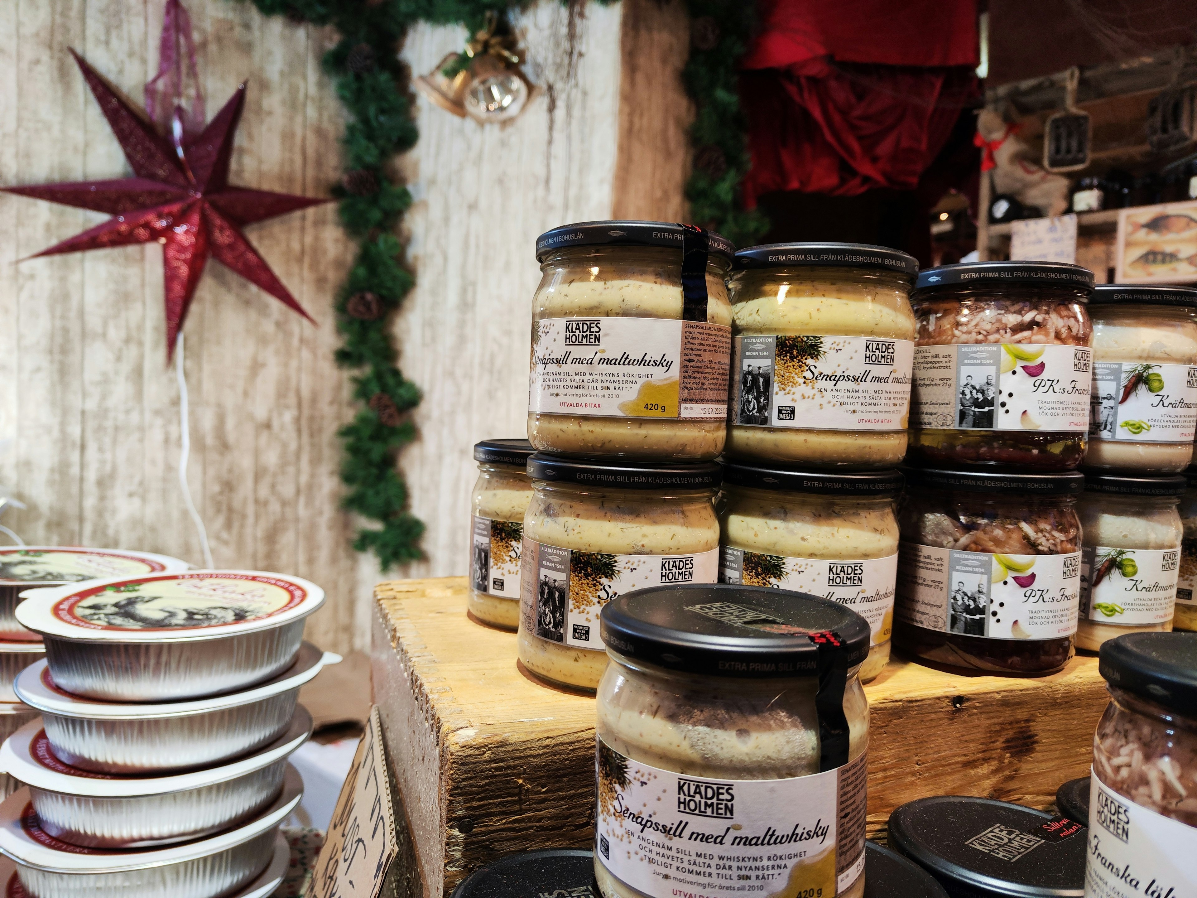 Jars of jams and spreads displayed at a Christmas market with a red star decoration