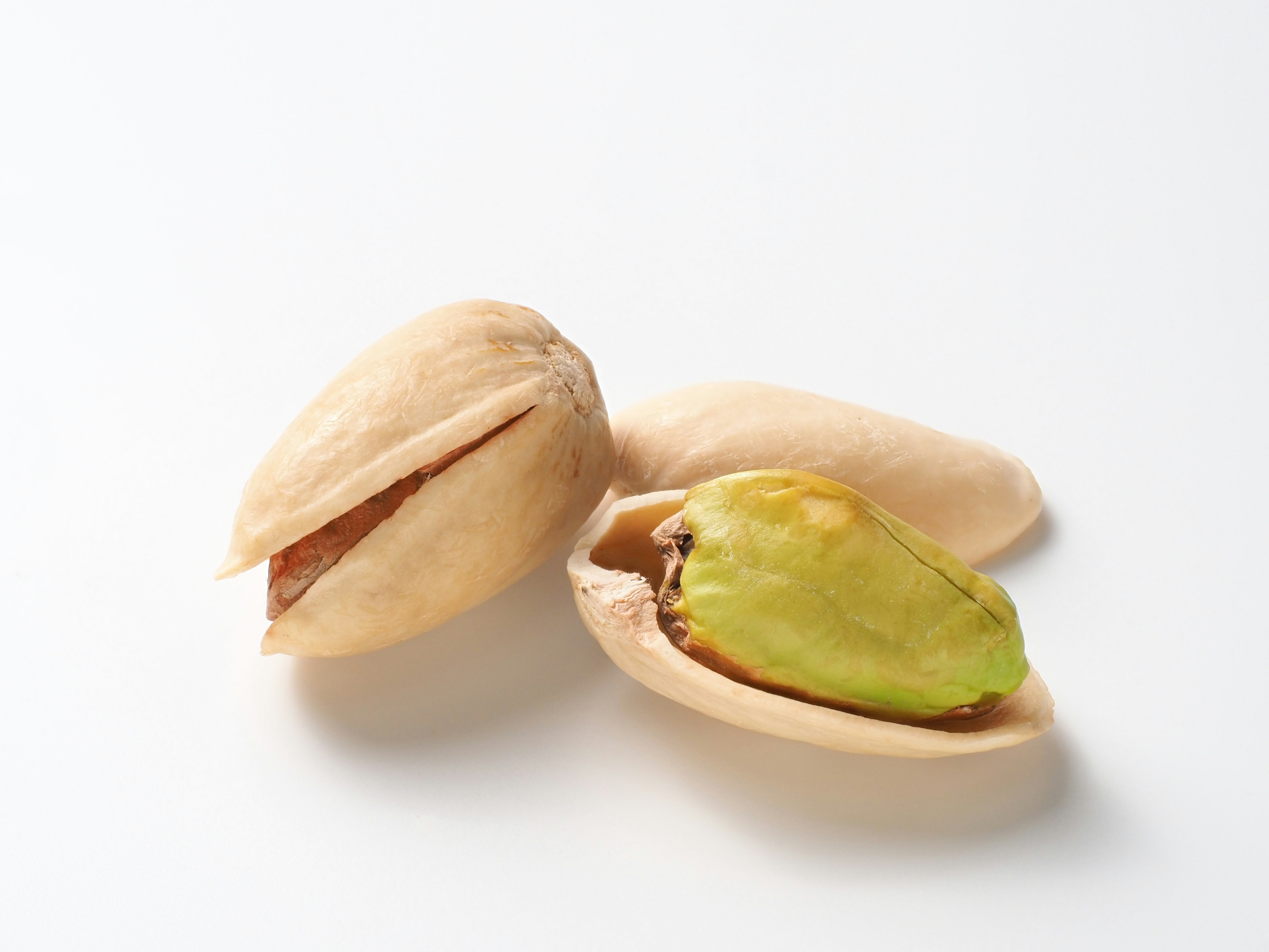 Pistachios with one shell open revealing a green nut