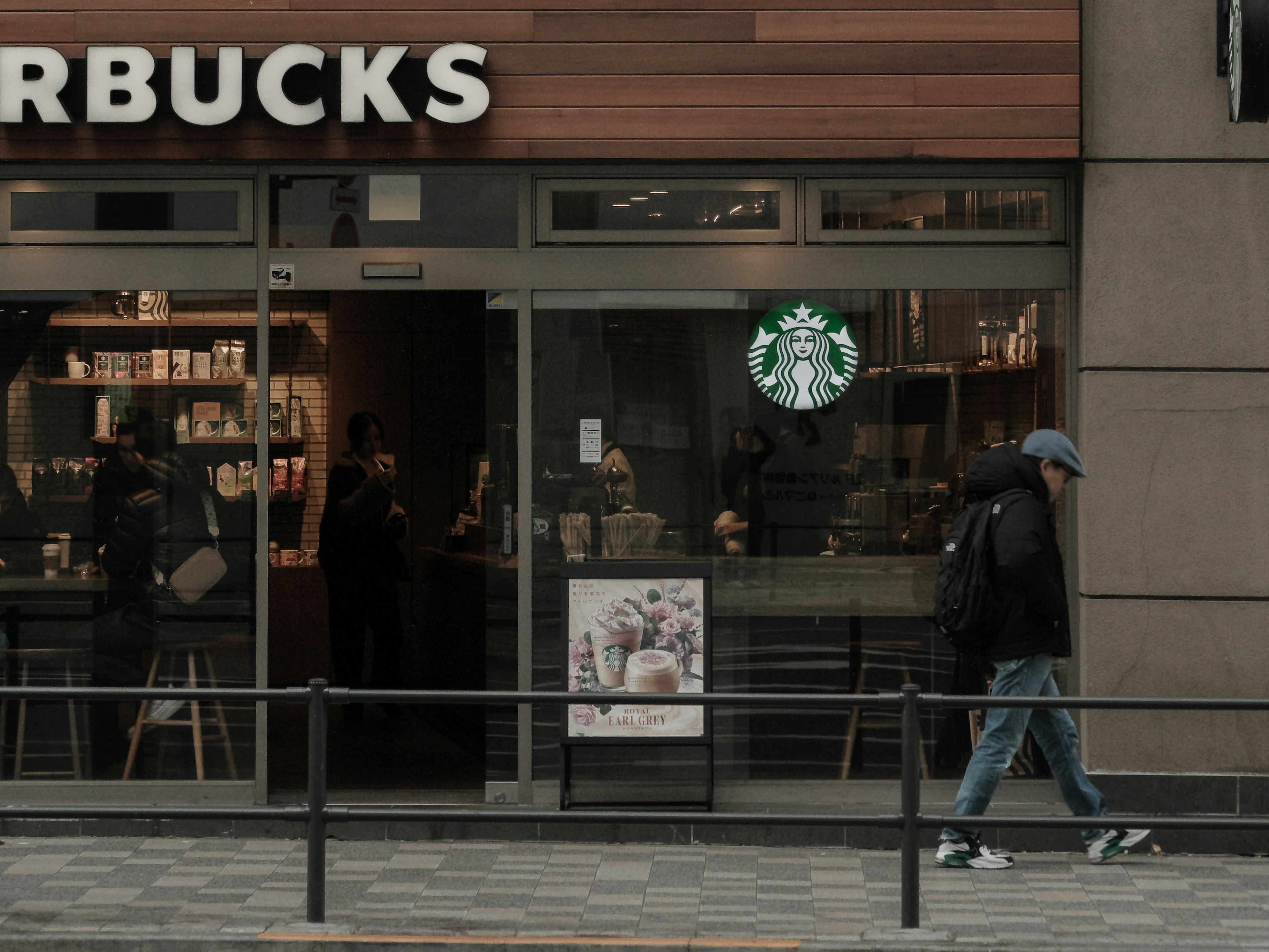 Fachada de Starbucks con un transeúnte