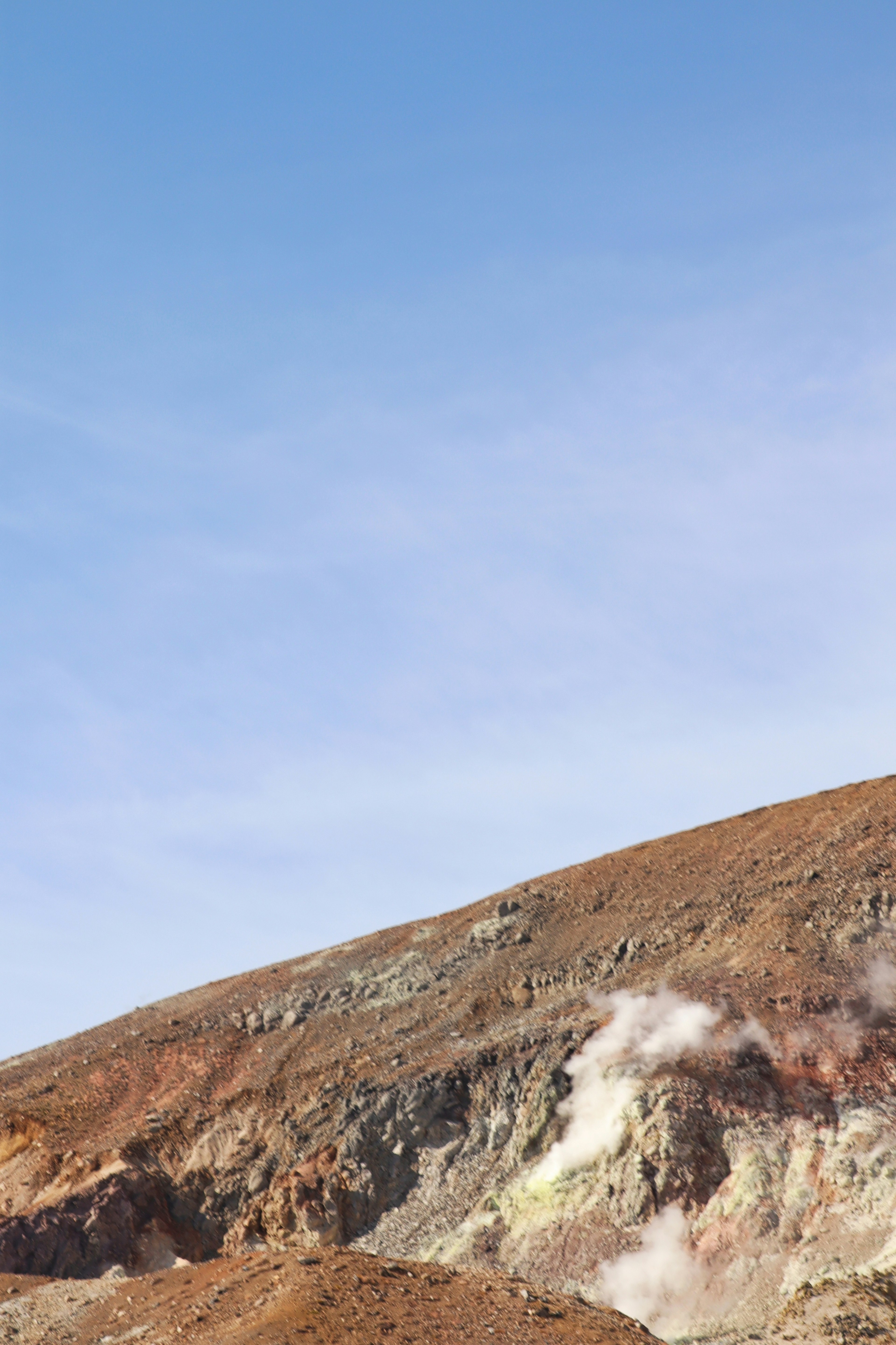 Berglandschaft mit Rauch unter blauem Himmel