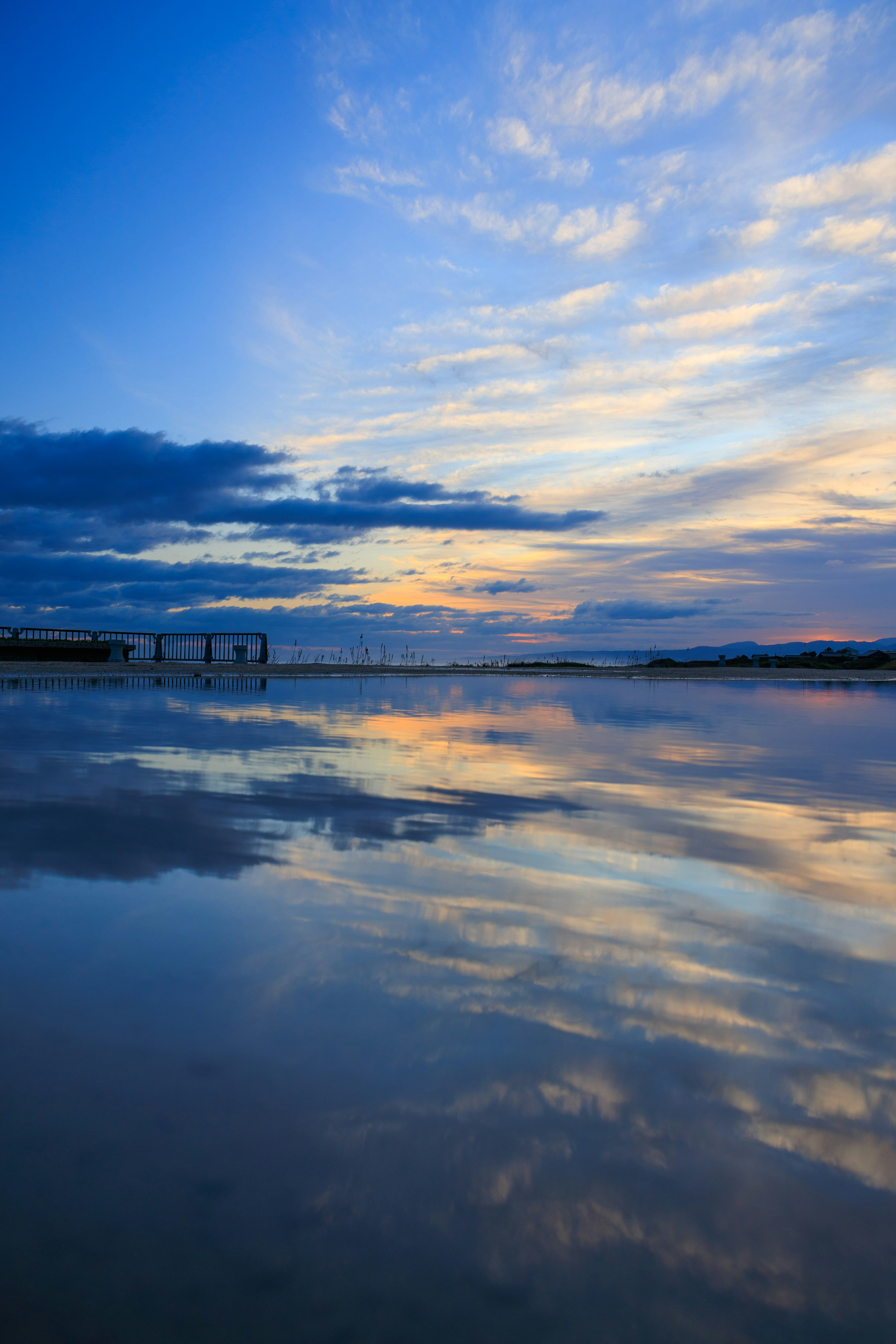 Paisaje tranquilo con cielo azul y nubes reflejadas en agua tranquila