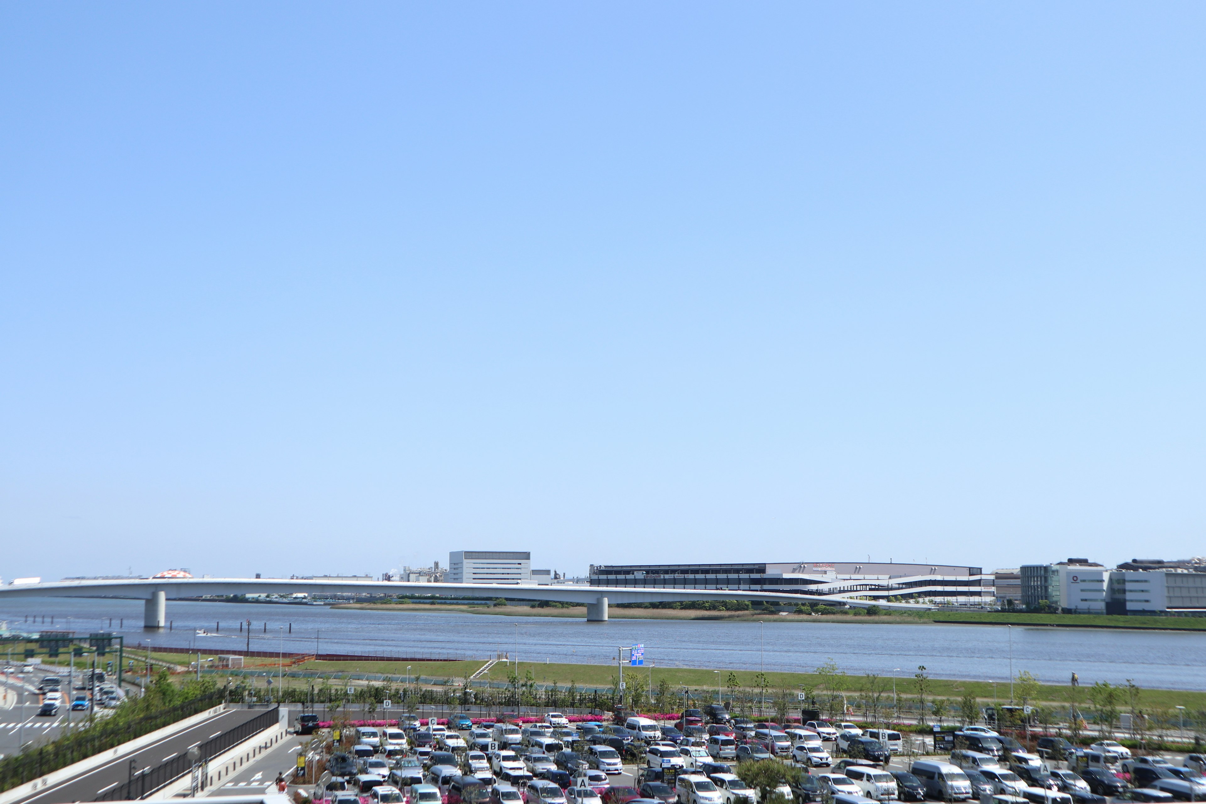 River landscape under a clear blue sky with a parking lot