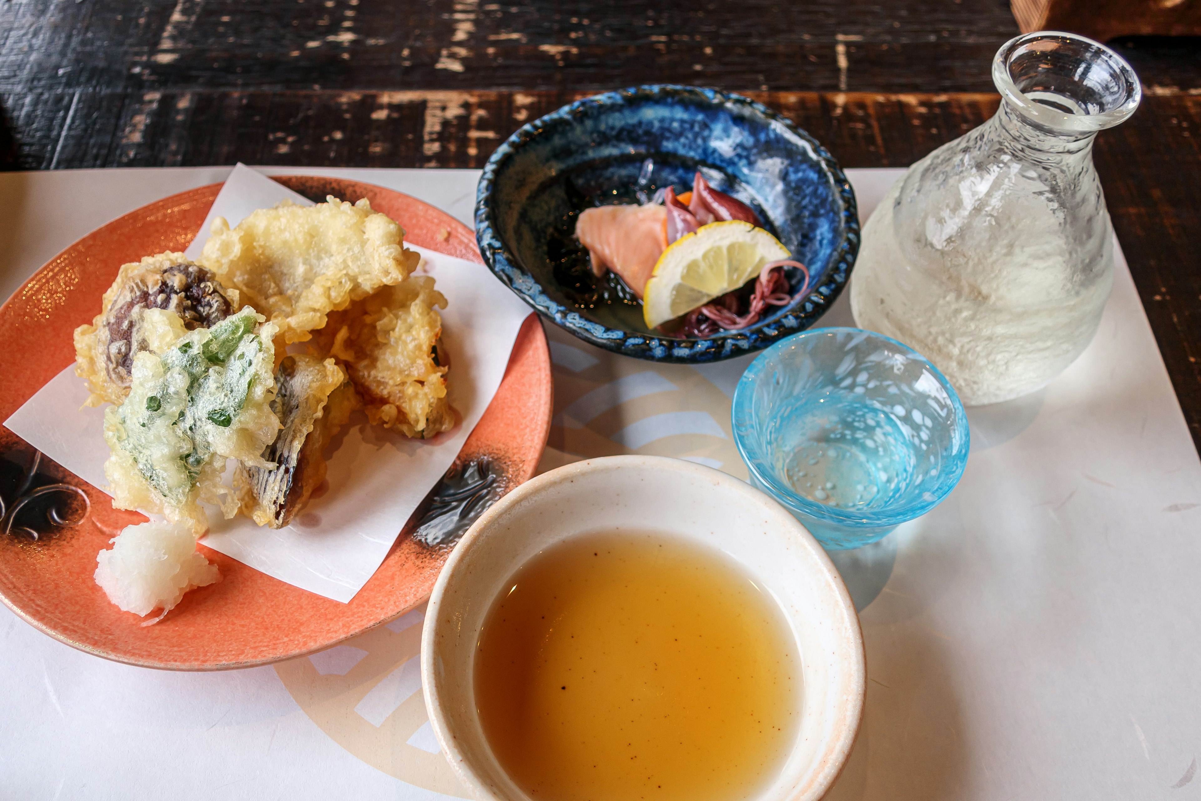 A plate of tempura and sake on a wooden table