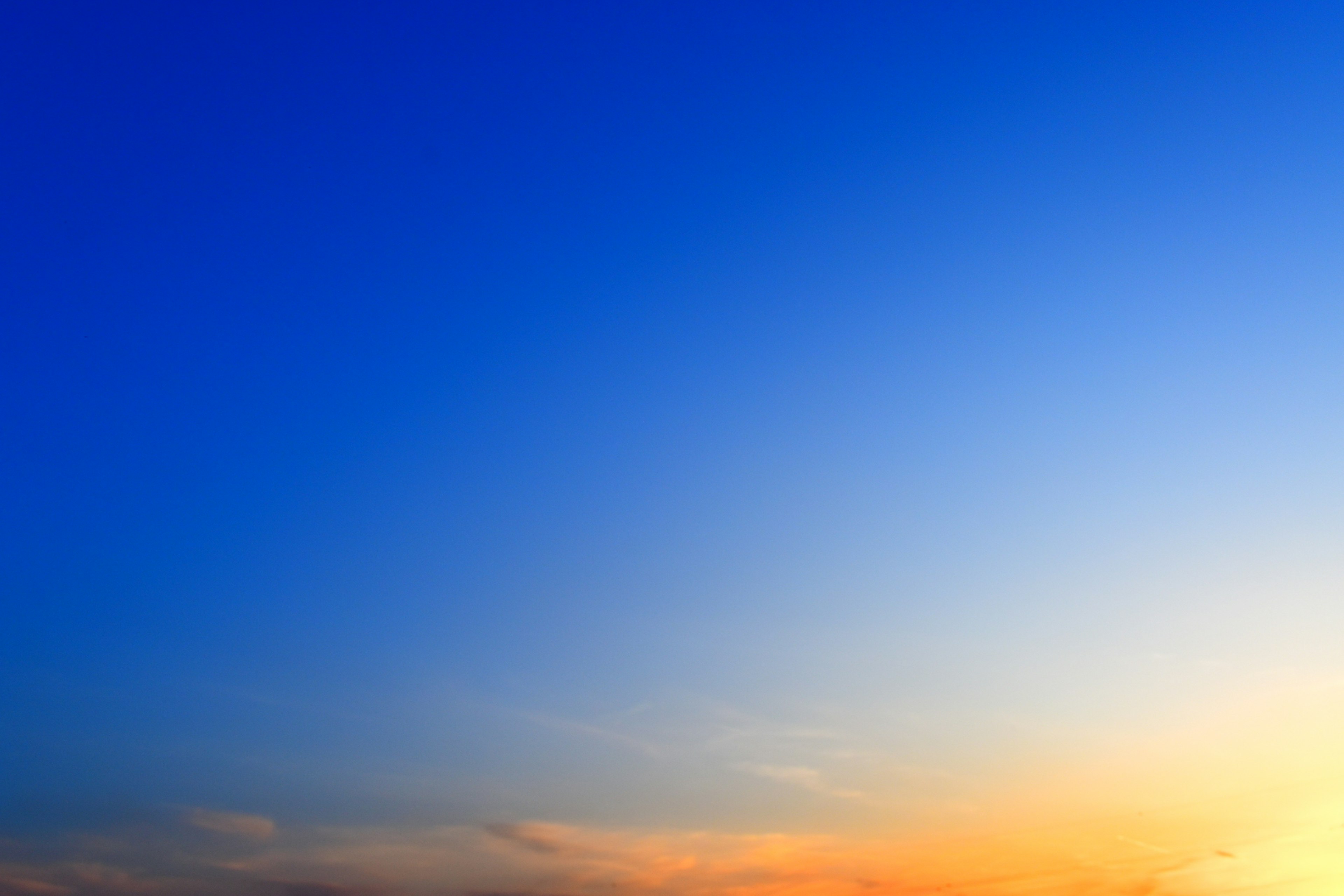 青い空とオレンジの夕焼けが広がる風景