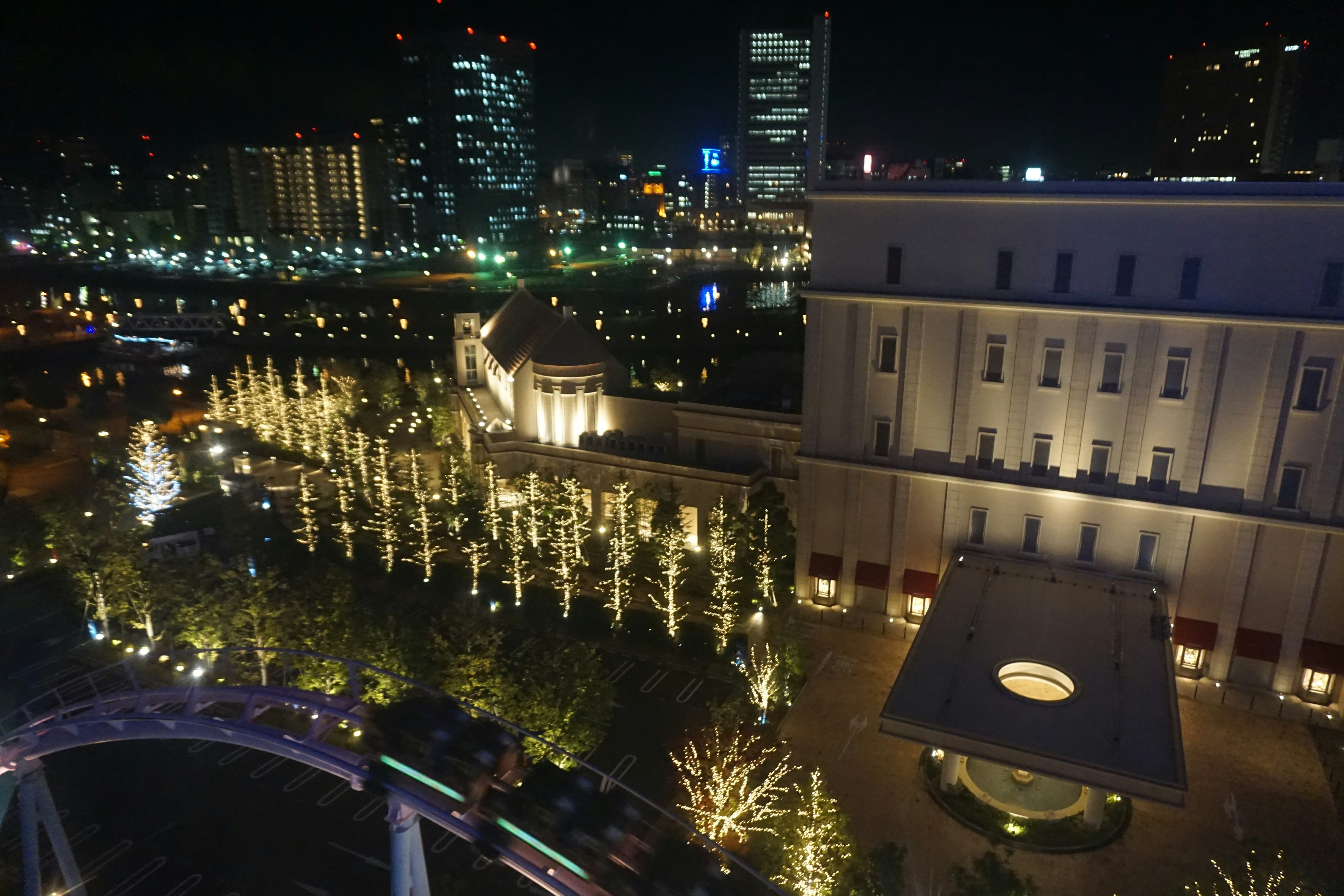 Pemandangan malam bangunan yang diterangi dan taman dengan lampu