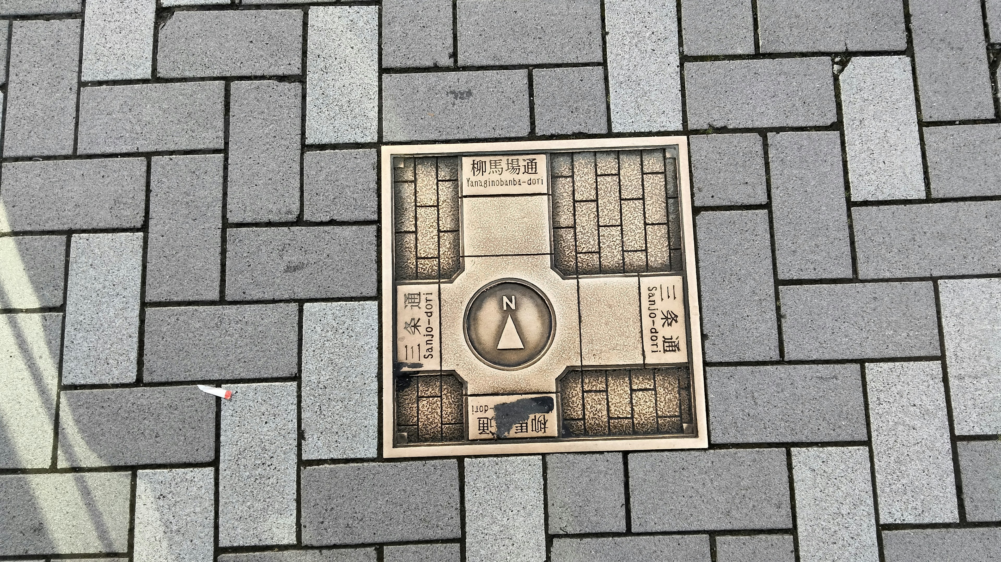 Unique design tile embedded in a paved walkway