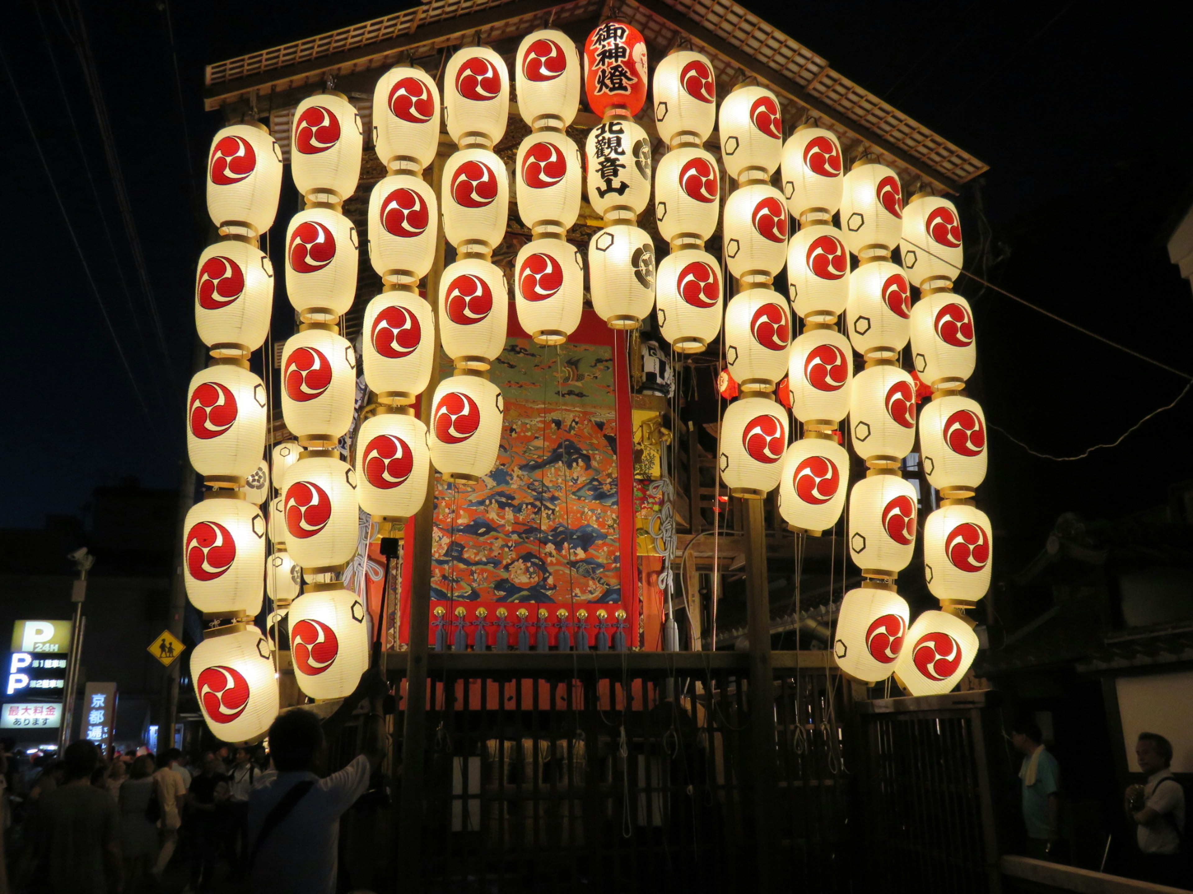 Traditional Japanese festival stage adorned with illuminated lanterns at night