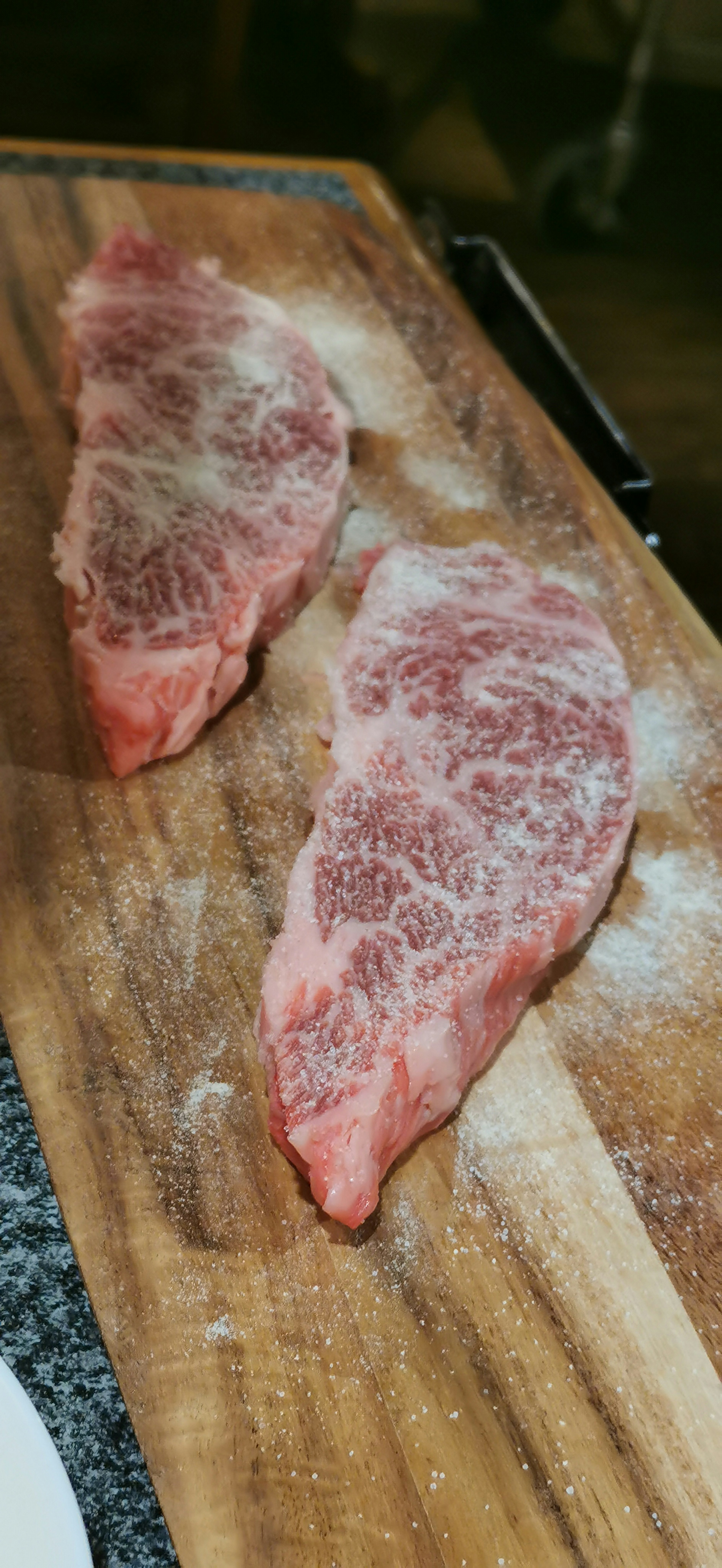 Slices of marbled wagyu beef on a wooden cutting board