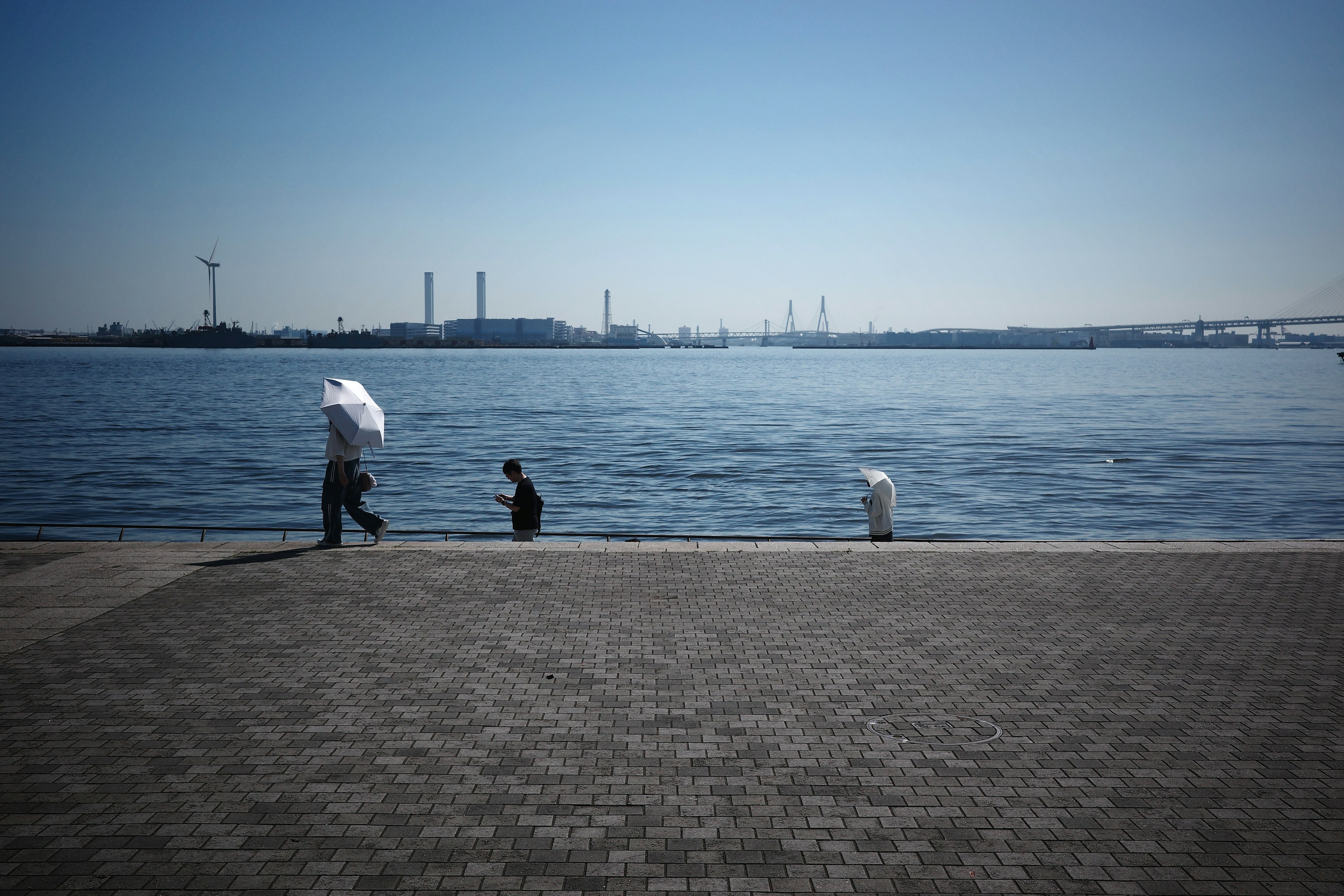 Des personnes au bord de l'eau avec un paysage d'usine