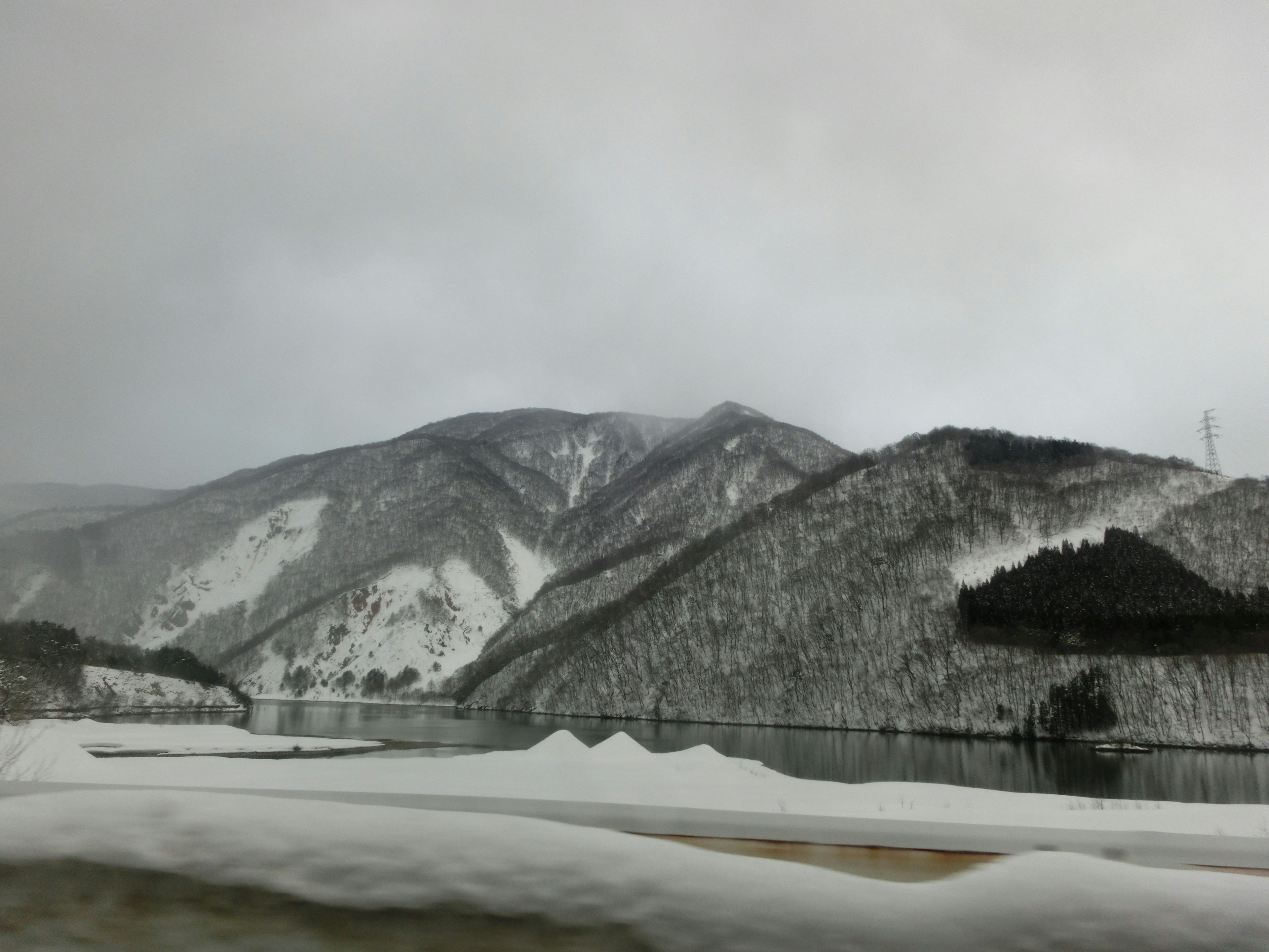 Winter landscape with snow-covered mountains and a tranquil lake