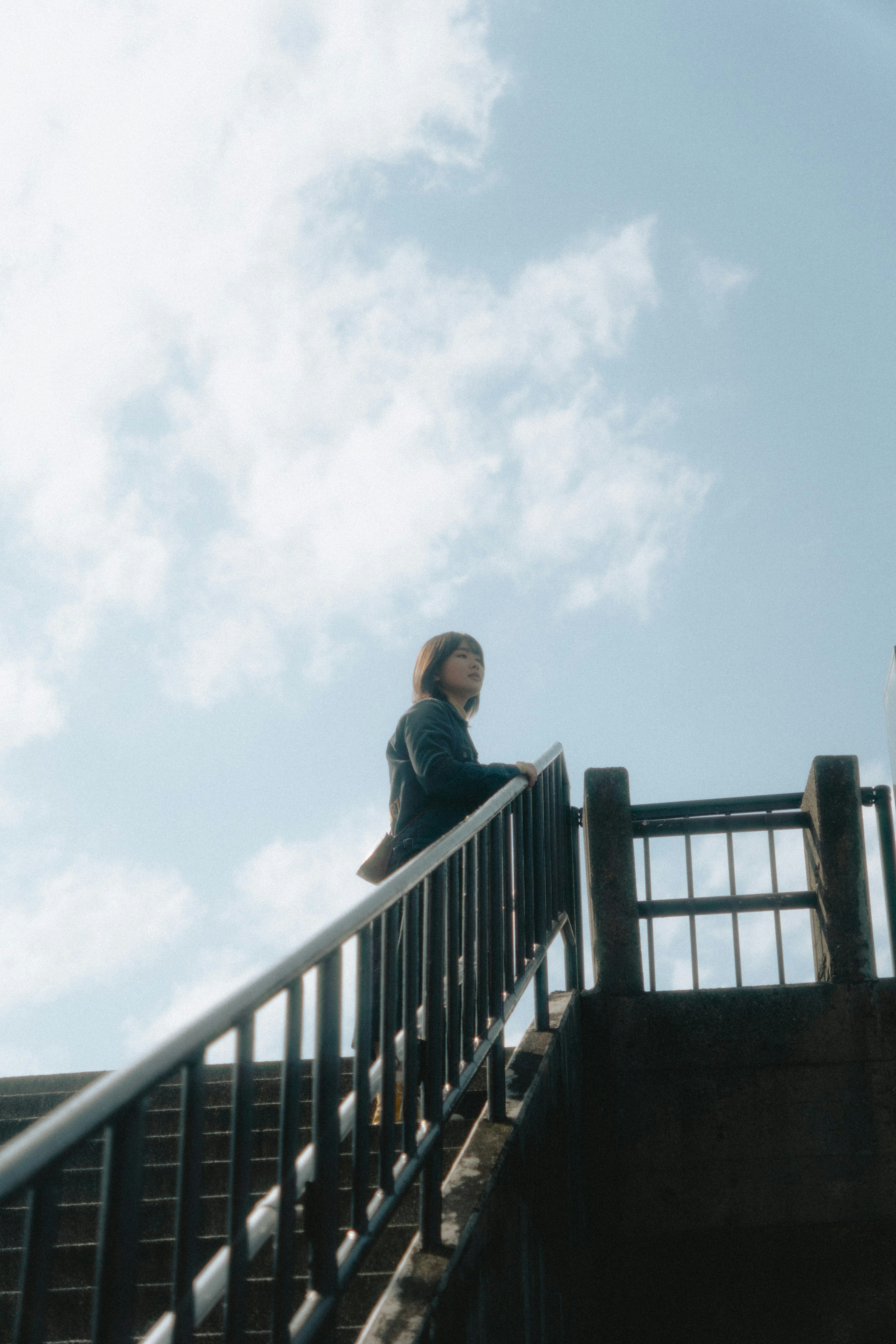 Frau, die unter einem blauen Himmel Treppen steigt