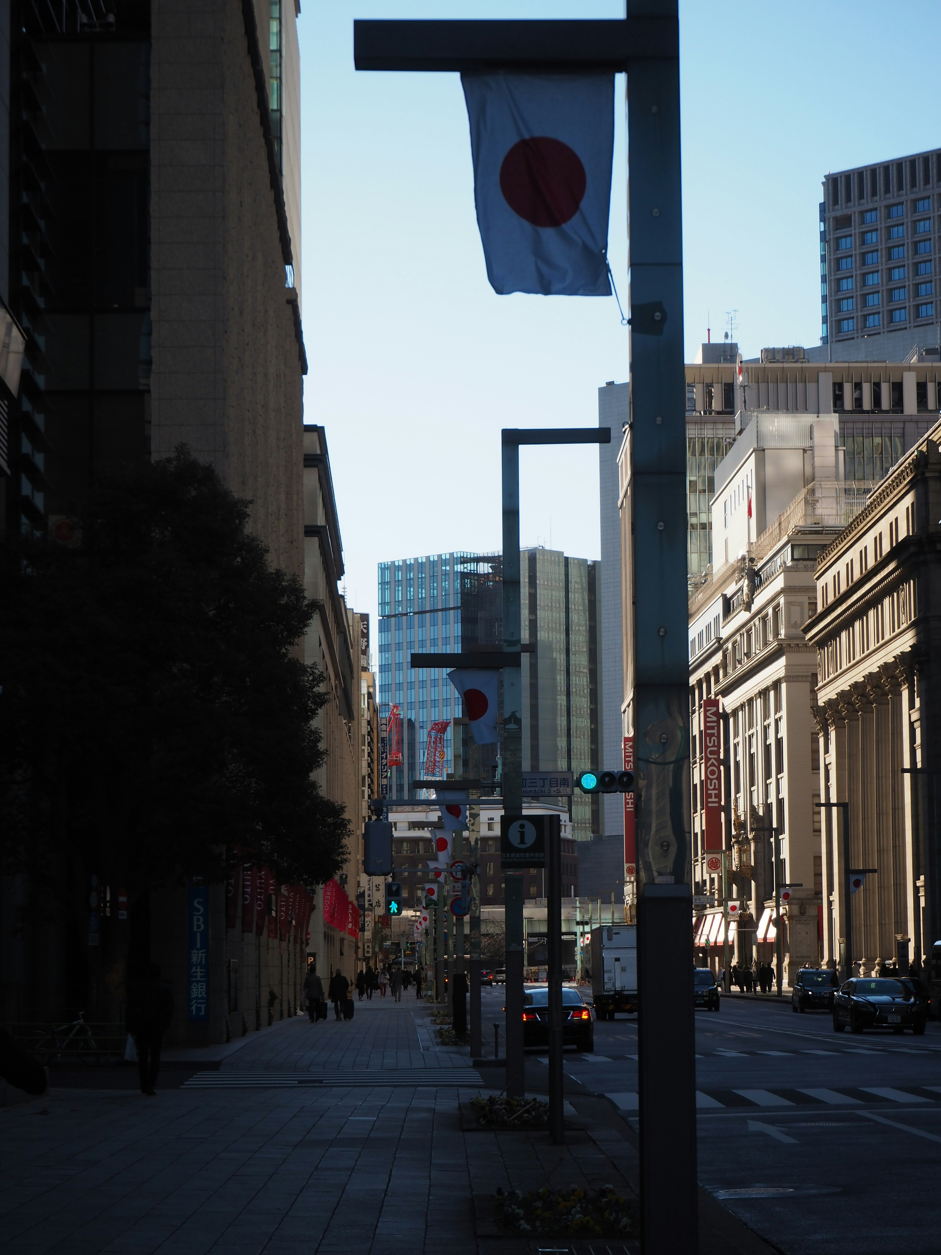 Street view featuring Japanese flags along the sidewalk