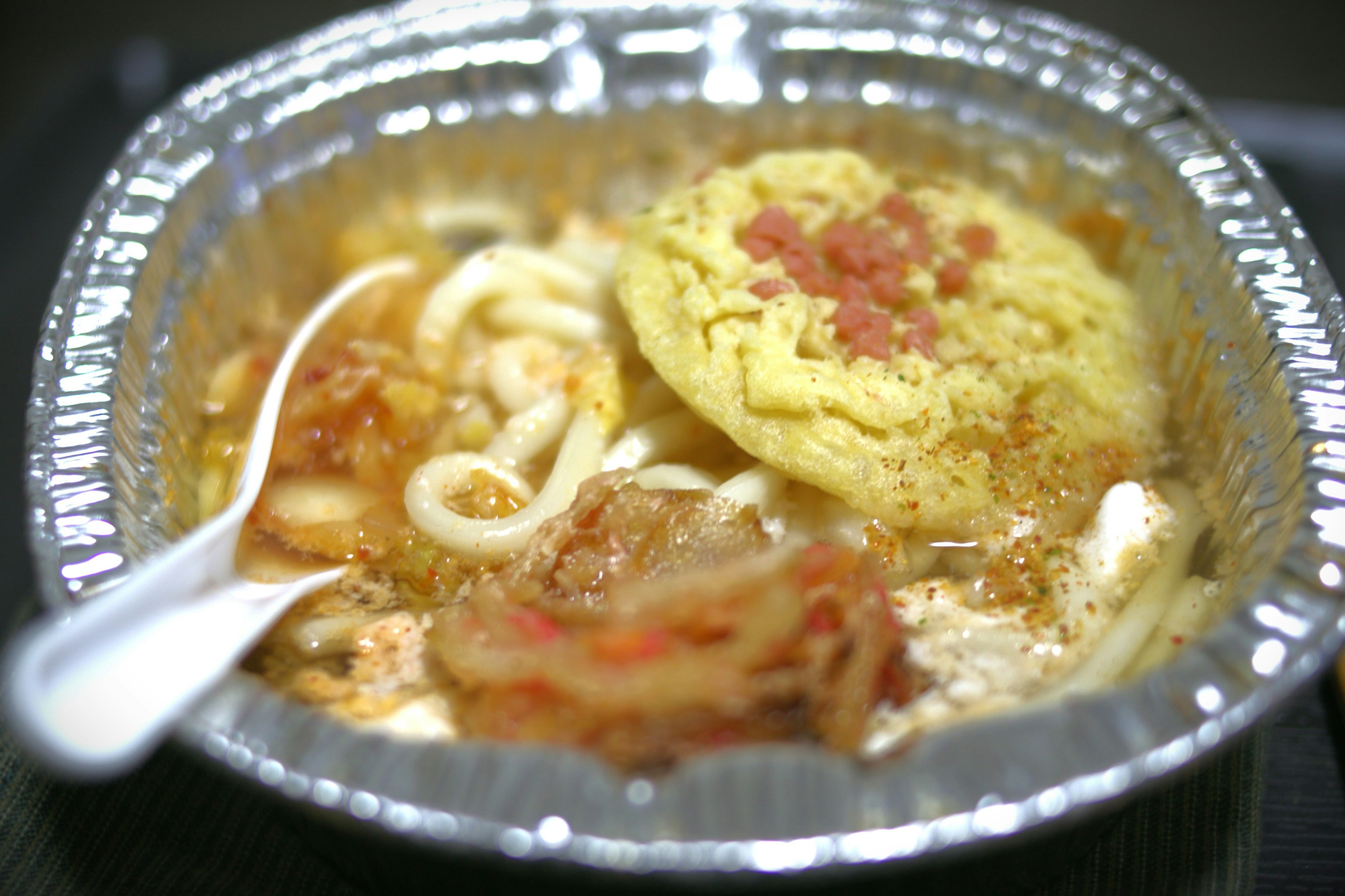 Fideos udon en caldo servidos en un recipiente plateado