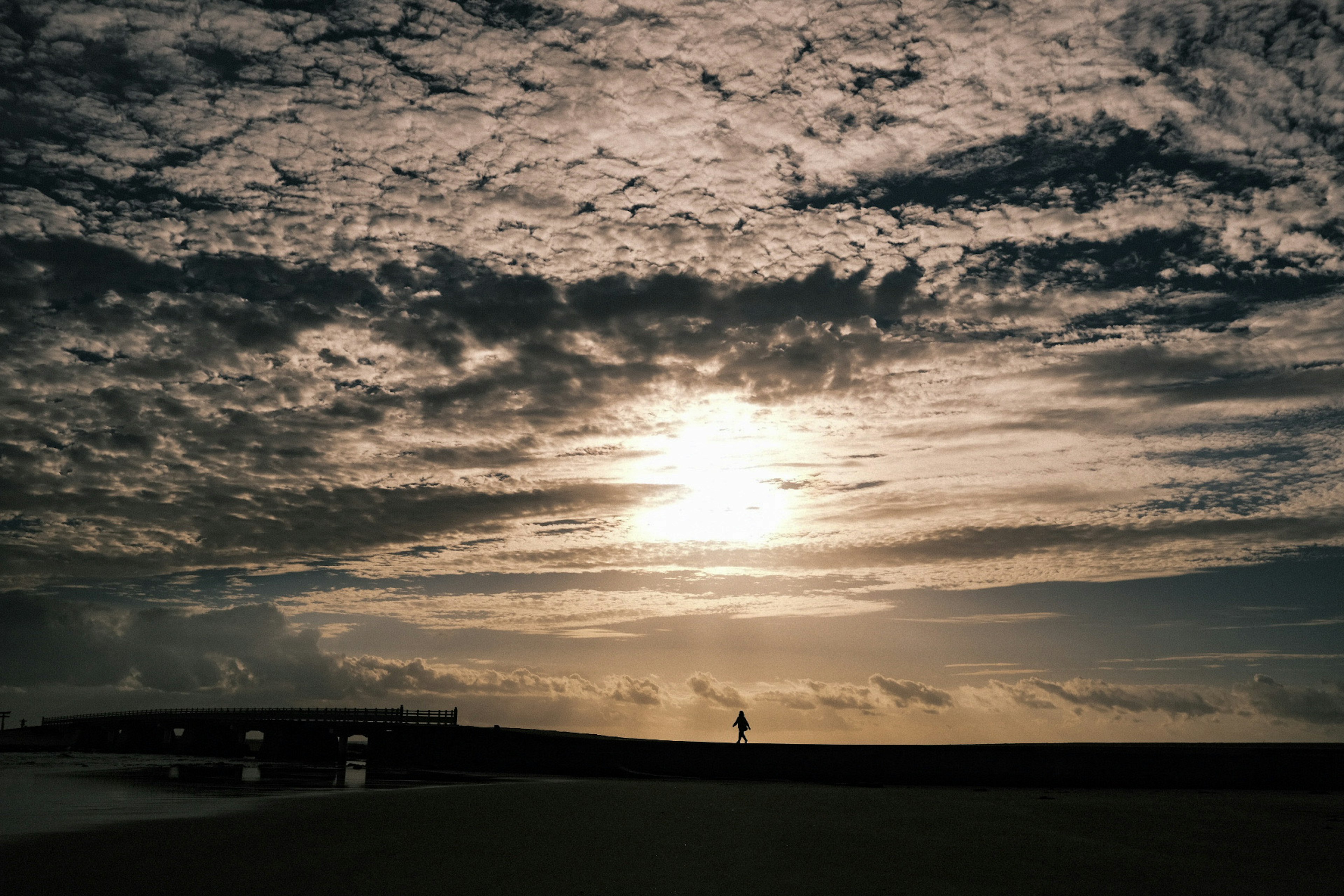 Paysage côtier avec le coucher de soleil à travers les nuages