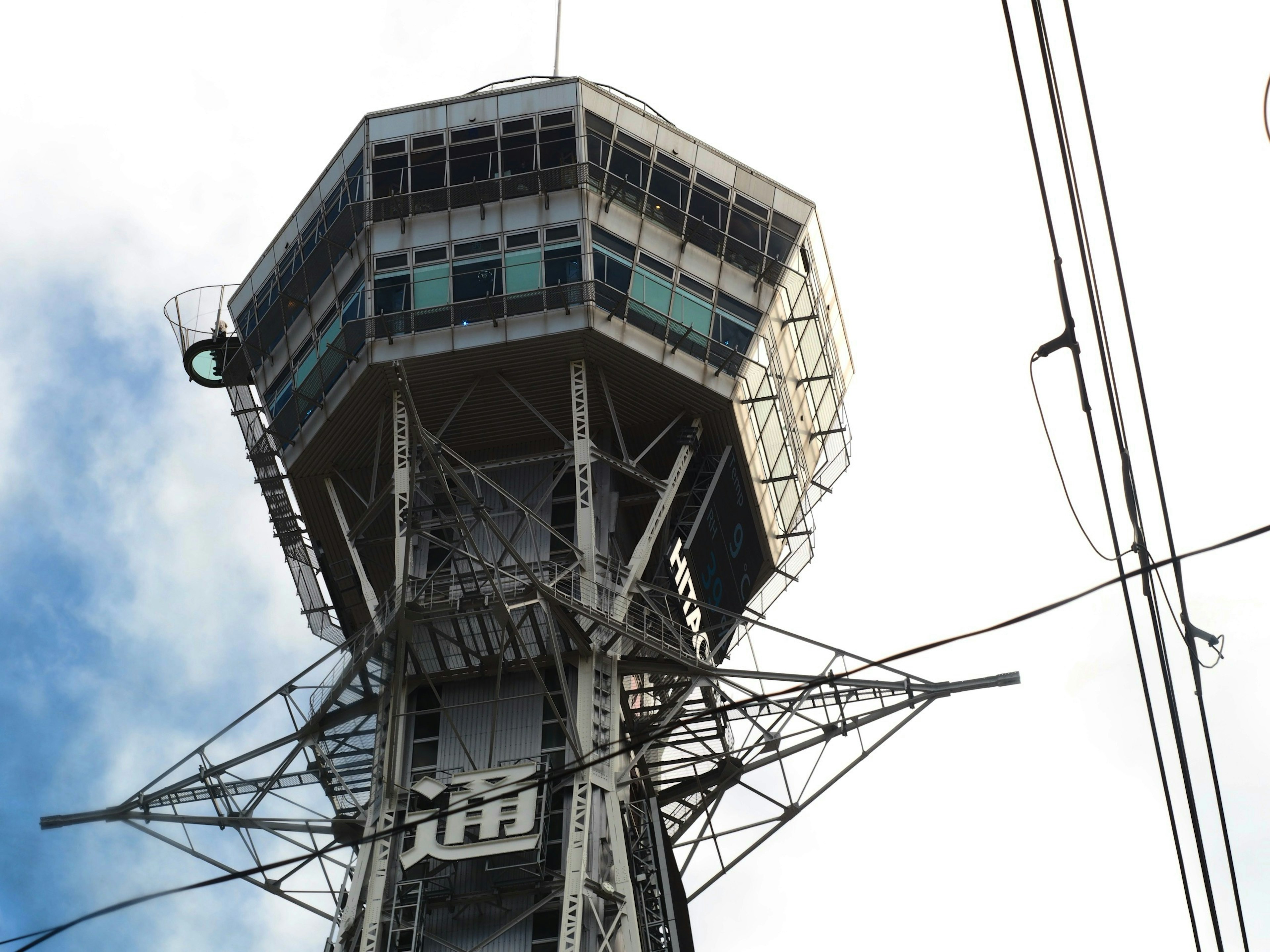 Upper structure of Tsutenkaku Tower in Osaka against blue sky