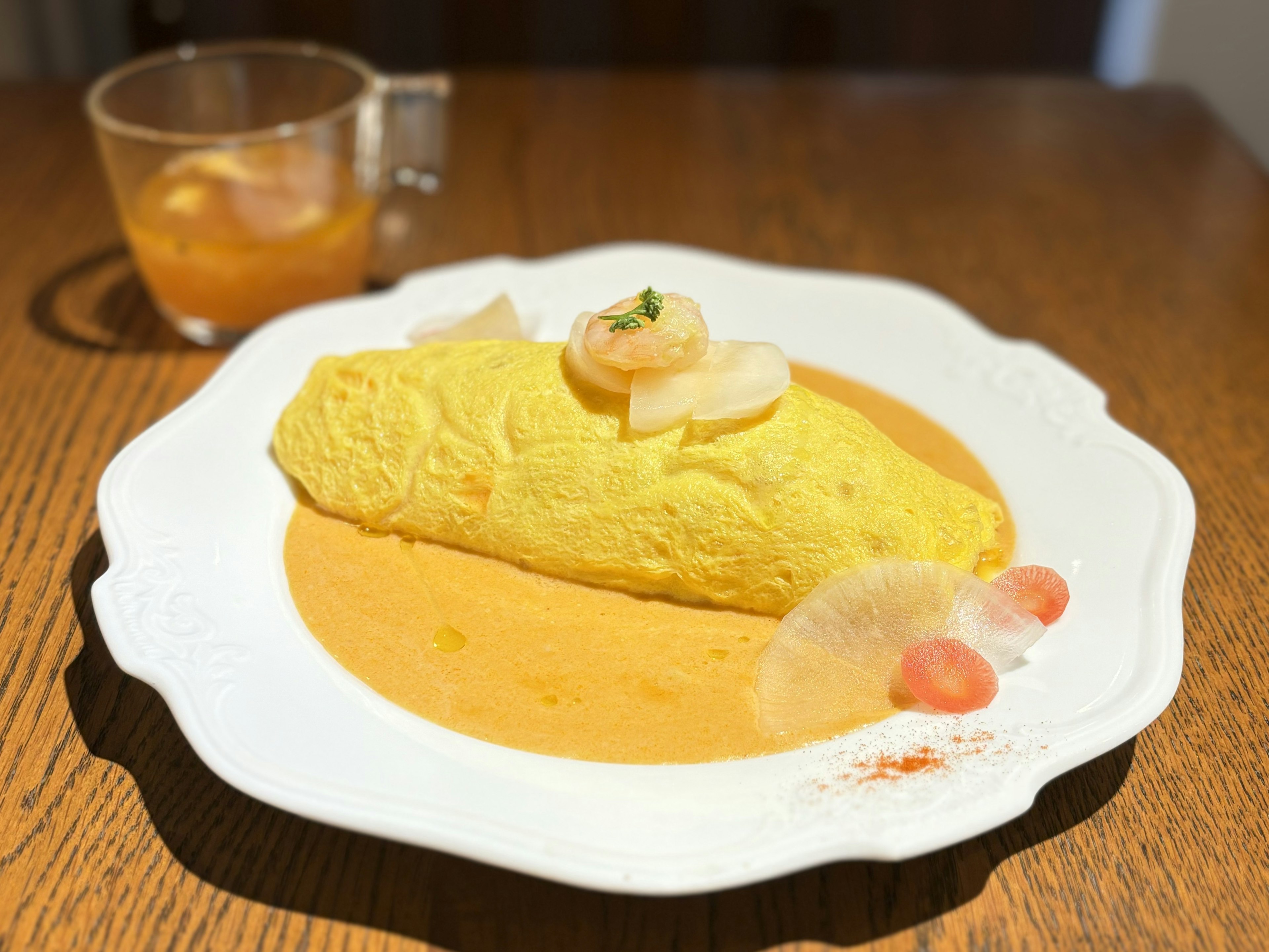 Gelbe Omelette auf cremiger Sauce mit Garnierungen serviert