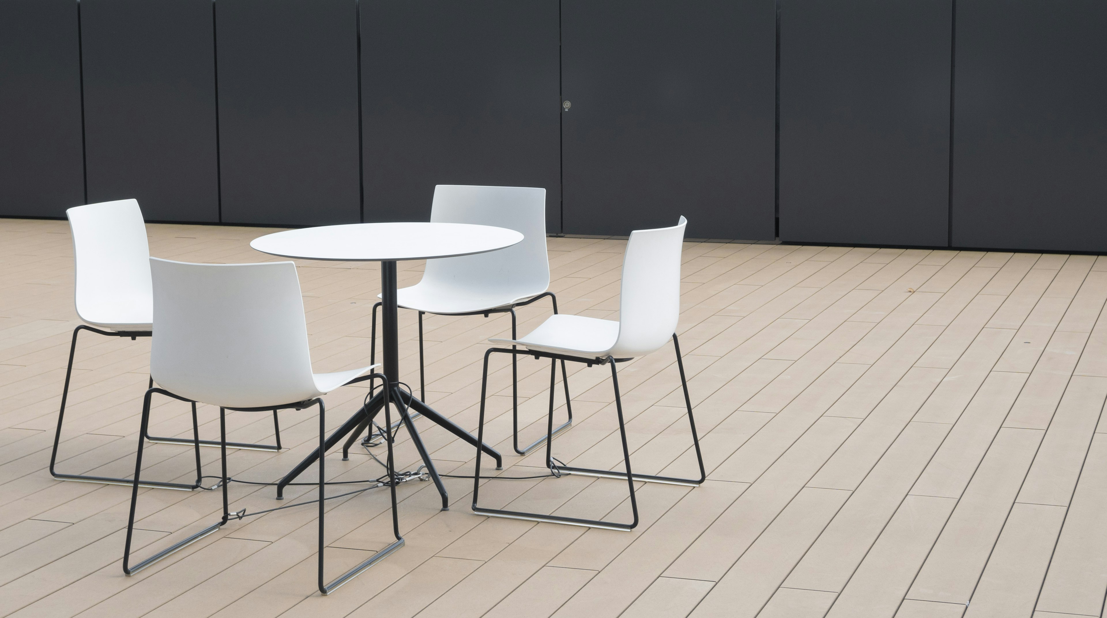 A simple outdoor space with a white table and chairs