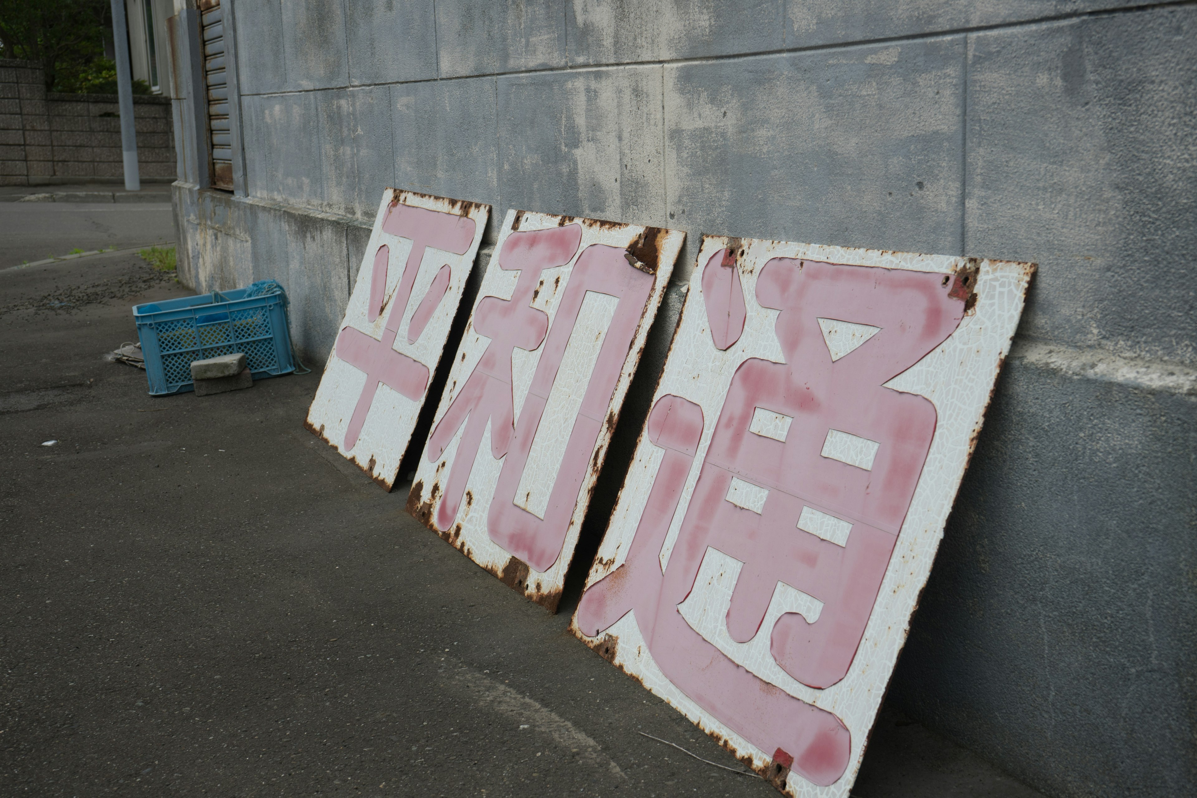 Old signs resting on the ground with faded pink characters