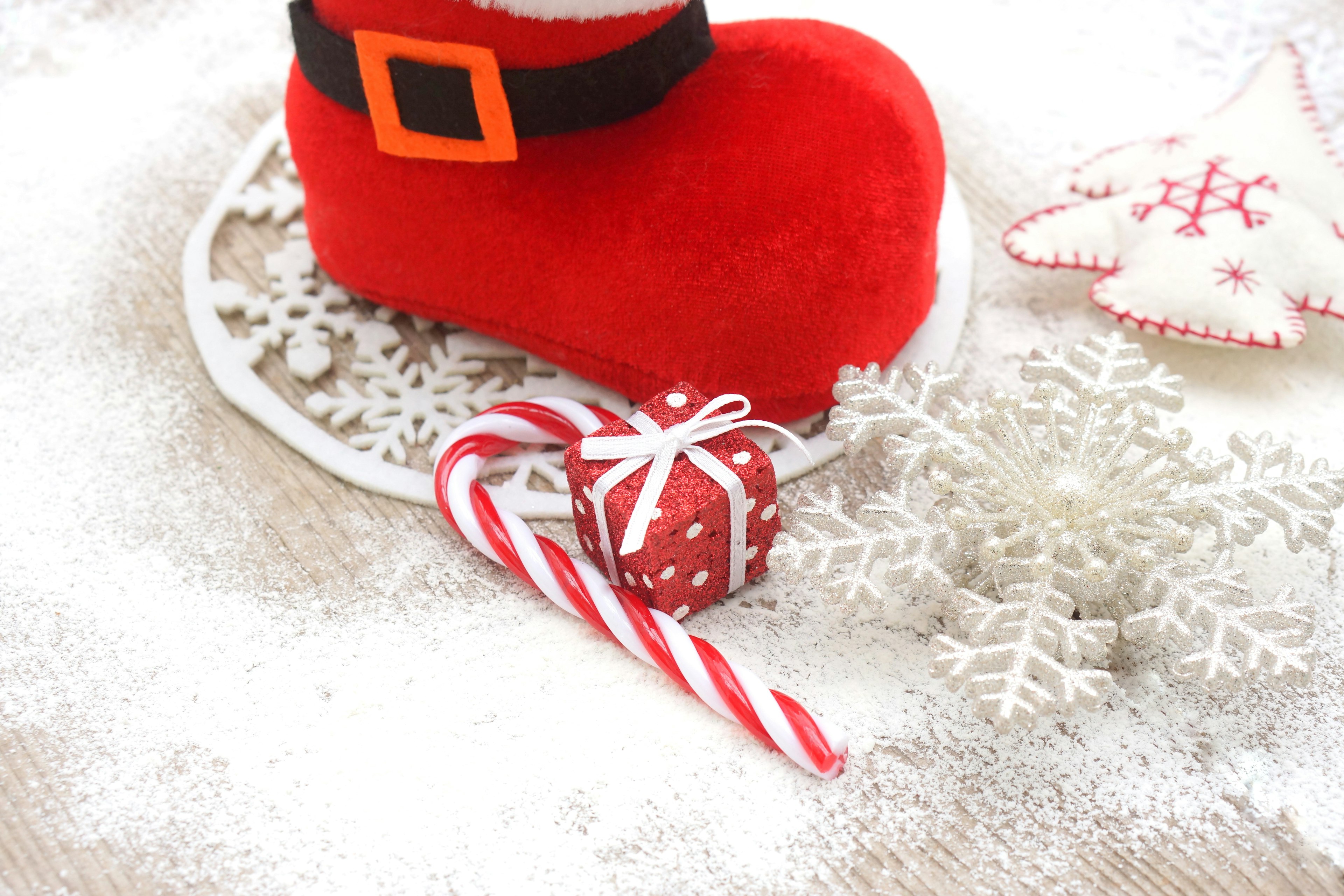 Botte de Santa rouge avec canne de bonbon et éléments décoratifs sur fond enneigé