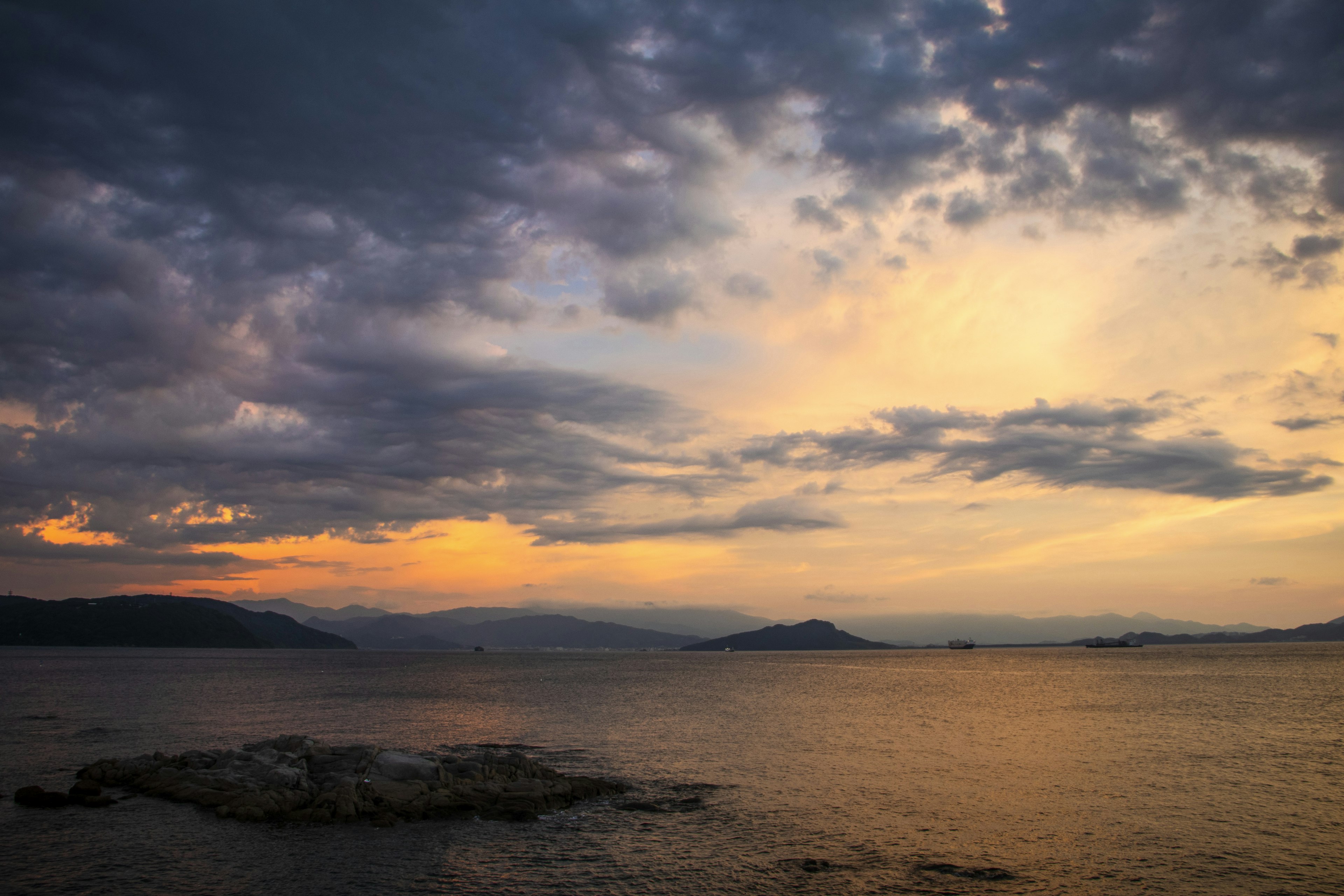 Schöner Sonnenuntergang über dem Meer dunkle Wolken und orangefarbener Himmel