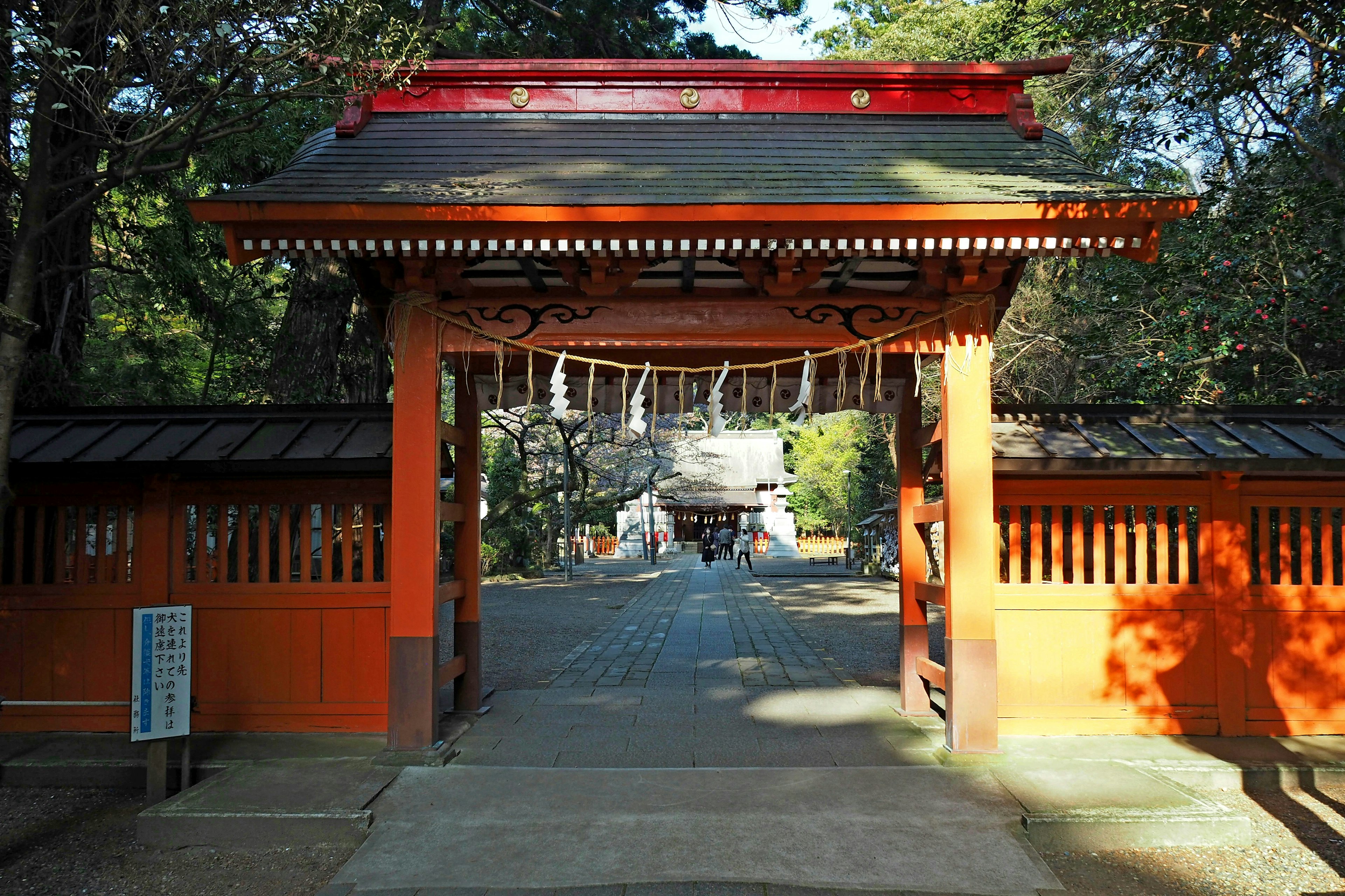 Pathway leading to a shrine gate with a red roof