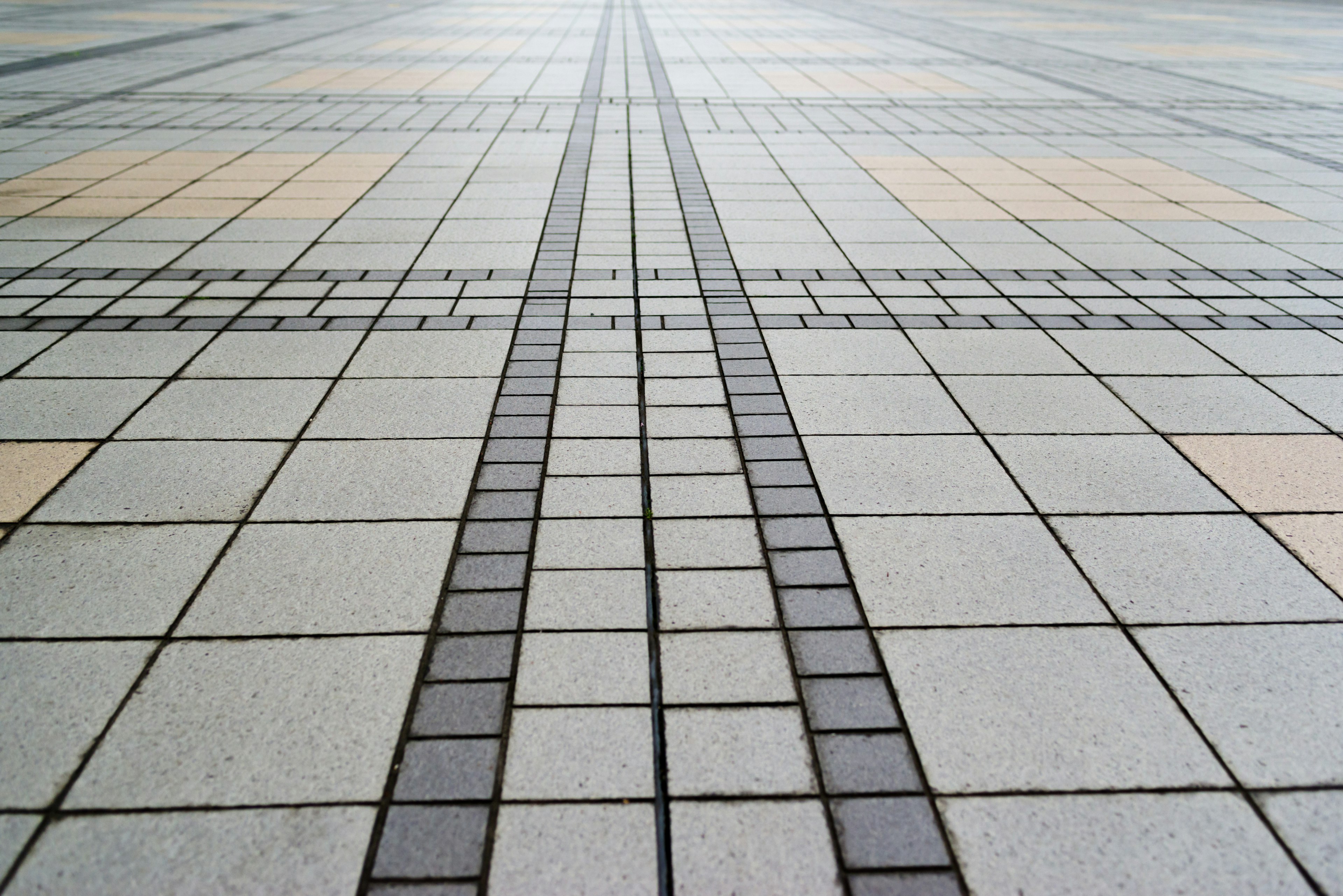 Image of a patterned tiled pavement with lines leading into the distance