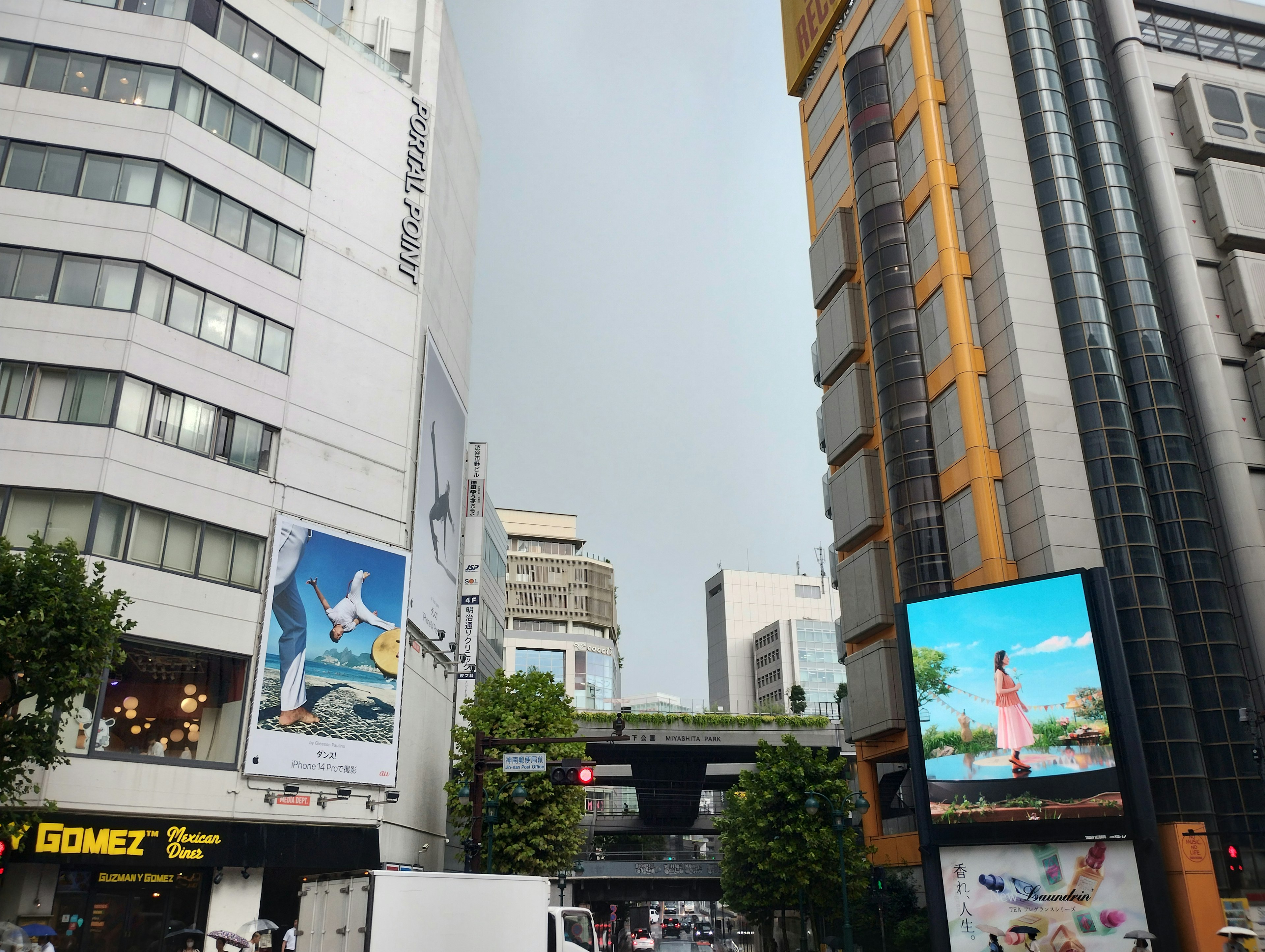 Persimpangan kota dengan gedung tinggi dan iklan cerah