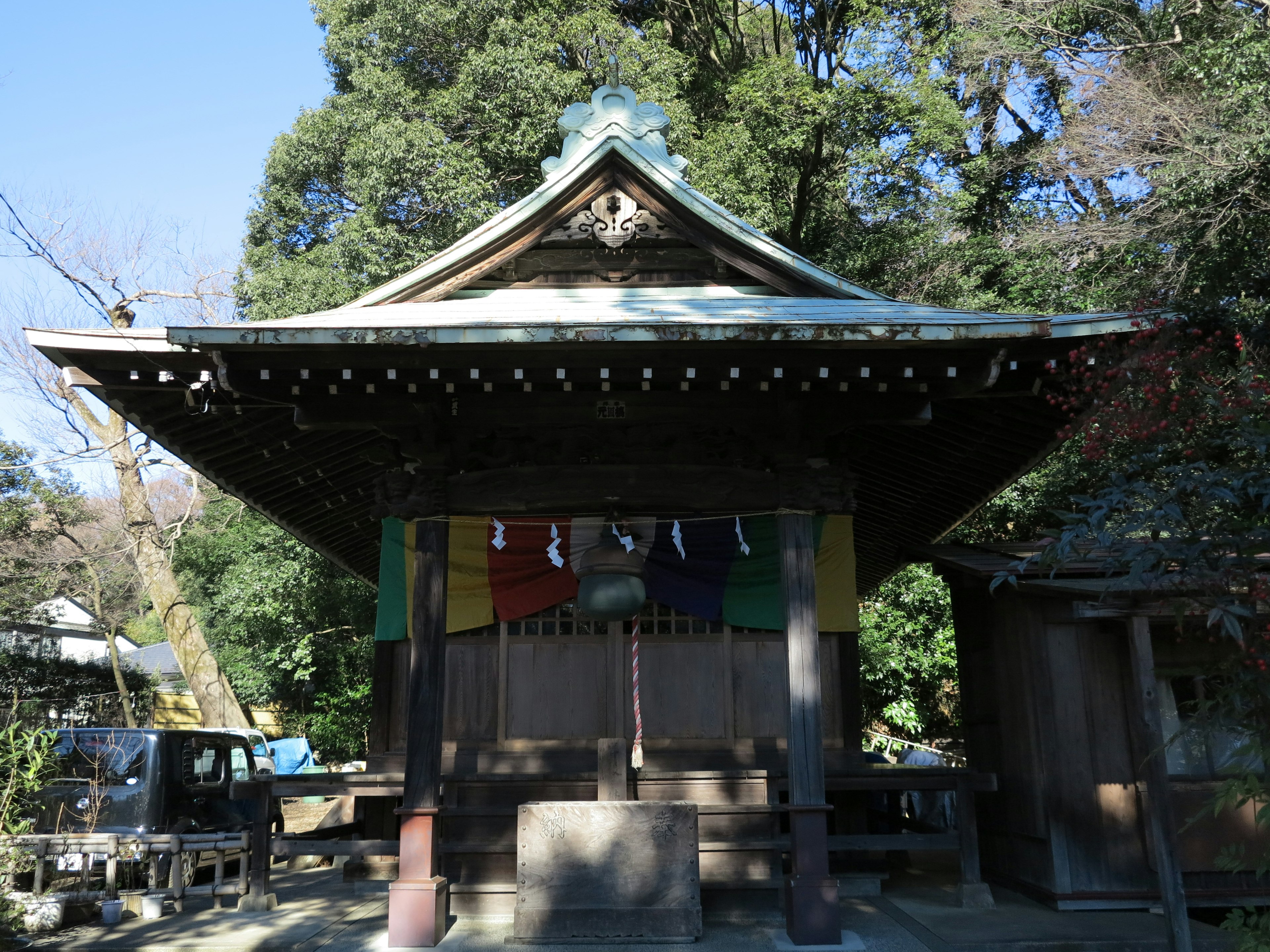 古い神社の建物と緑の木々の背景