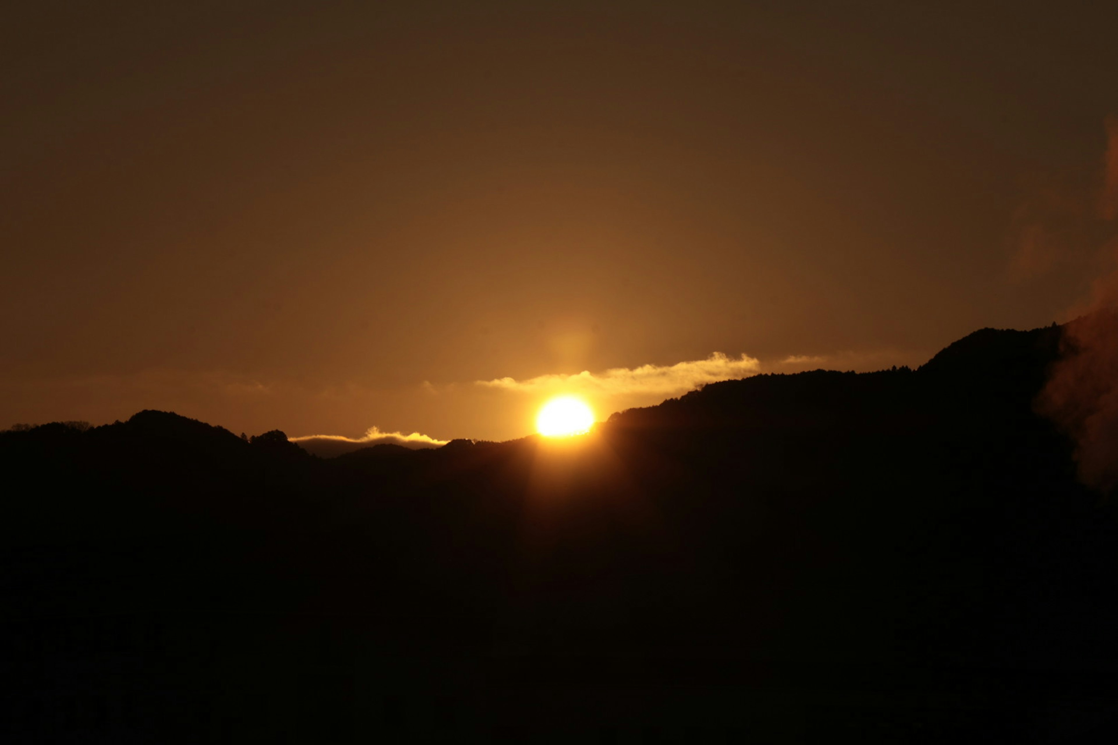 Sonnenaufgang über den Bergen mit klarem Horizont